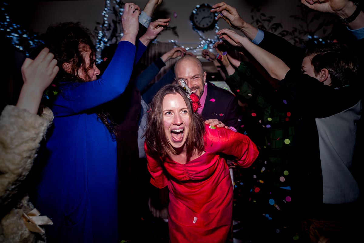 Annie walks through a tunnel of wedding guests at the village hall in Firle.