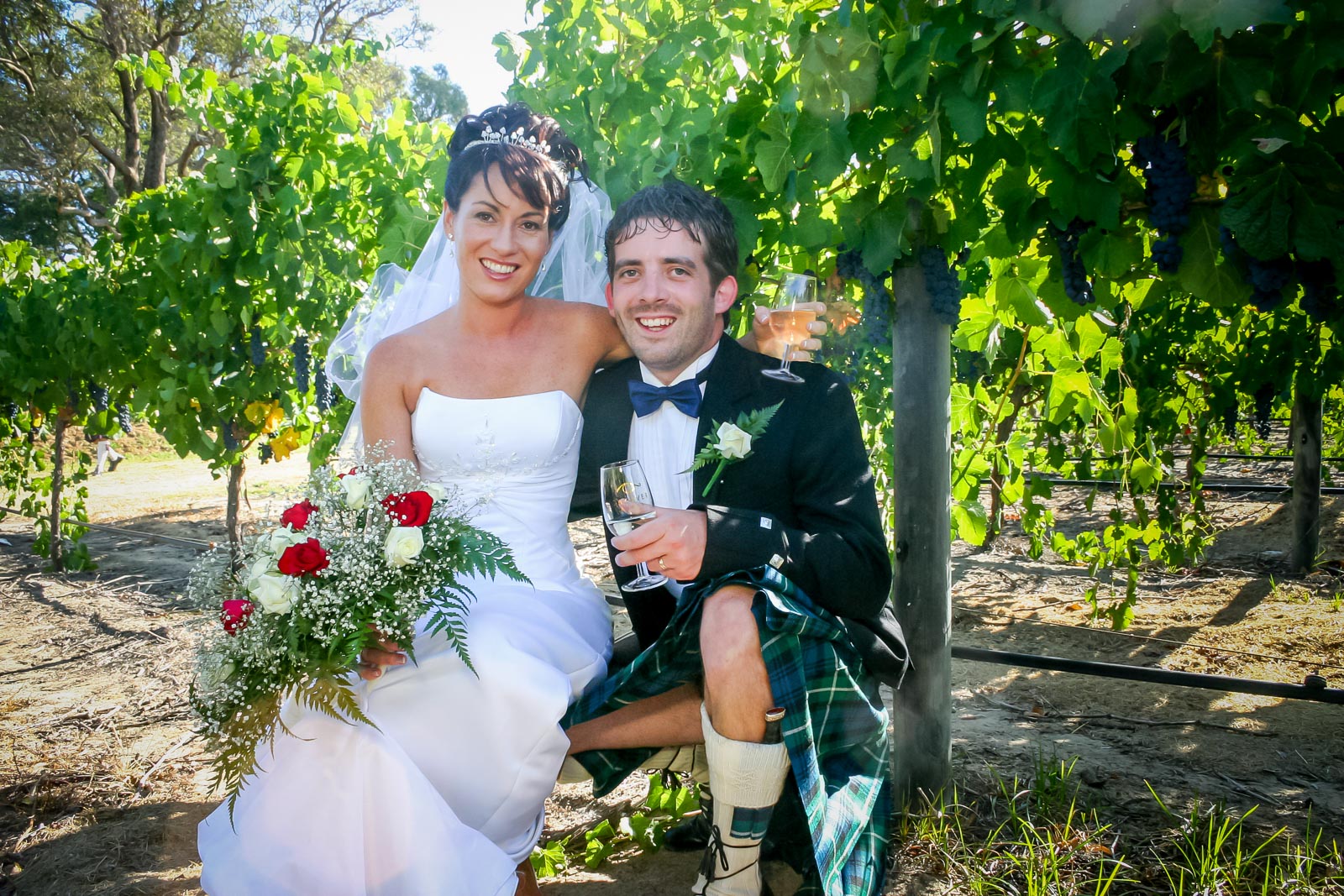 Russ and Megs pose amongst grape vines after their wedding.