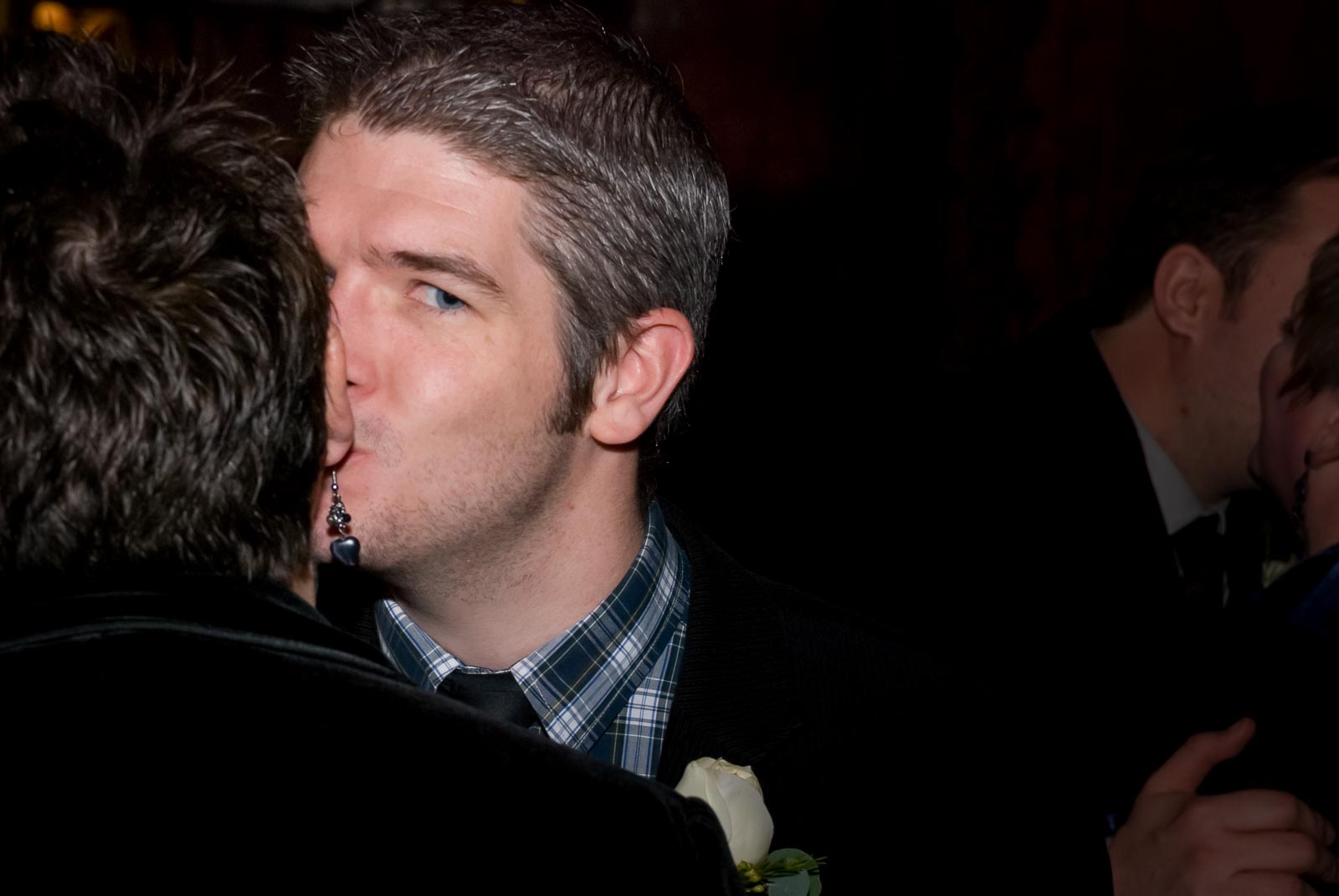 A guest kisses another guest at Laura and Paula's civil partnership inside Brighton Dome.