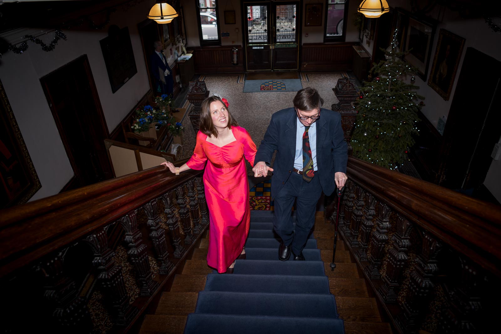 Annie ascends the stairs at Lewes Town Hall accompanied by her father before her wedding to Mark.