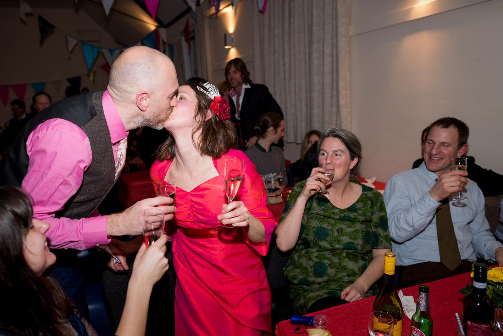 Annie and Mark embrace after their wedding on front of guests in Firle Village Hall.