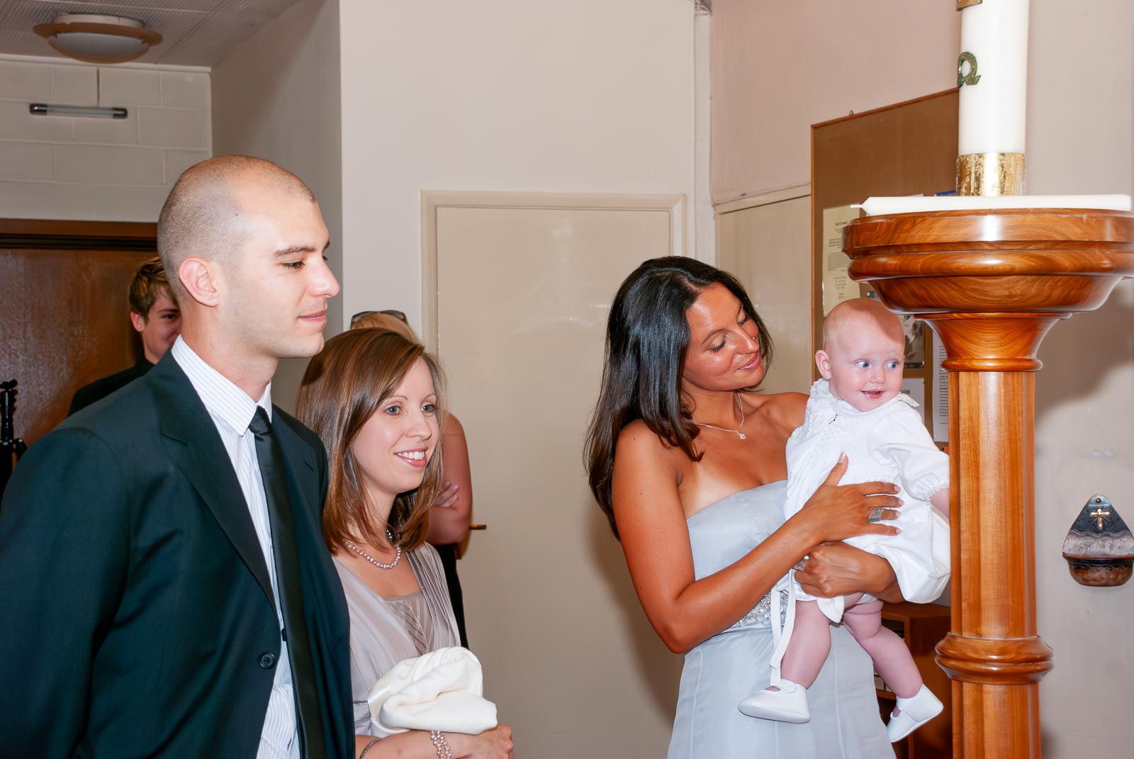 Amalie, her mum and her god parents wait to be baptised. 