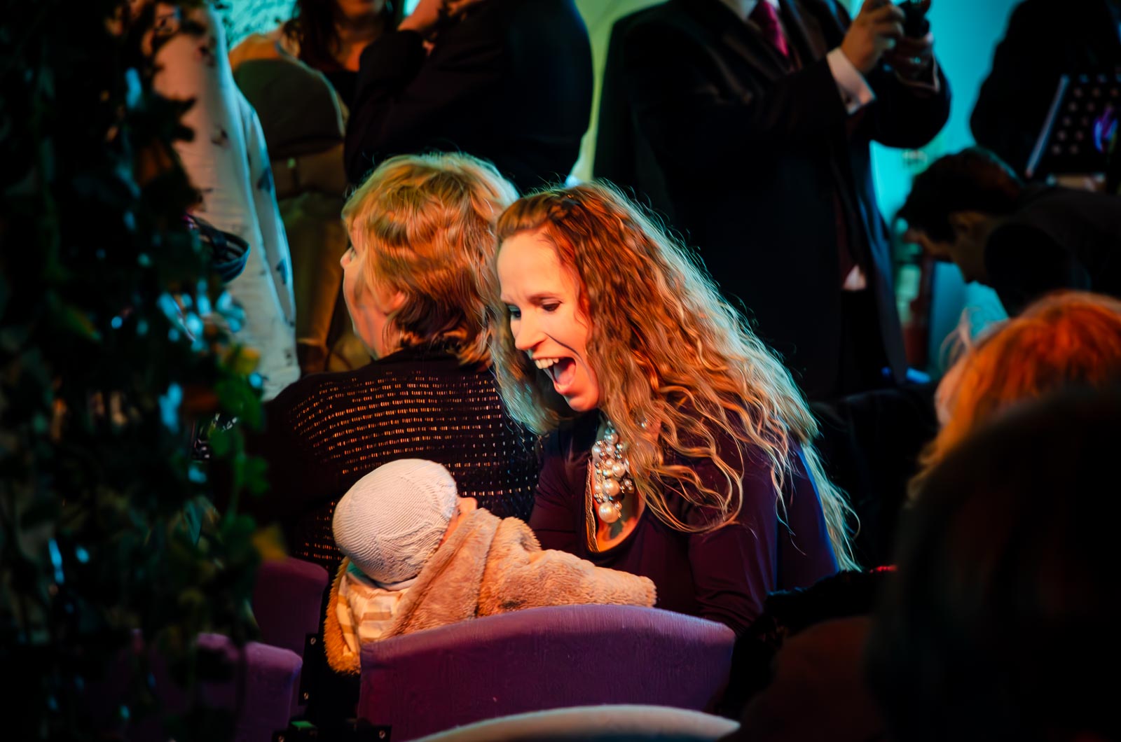 A wedding guest entertains her baby during Jon and Lou's wedding at St Michaels Church in Brighton.