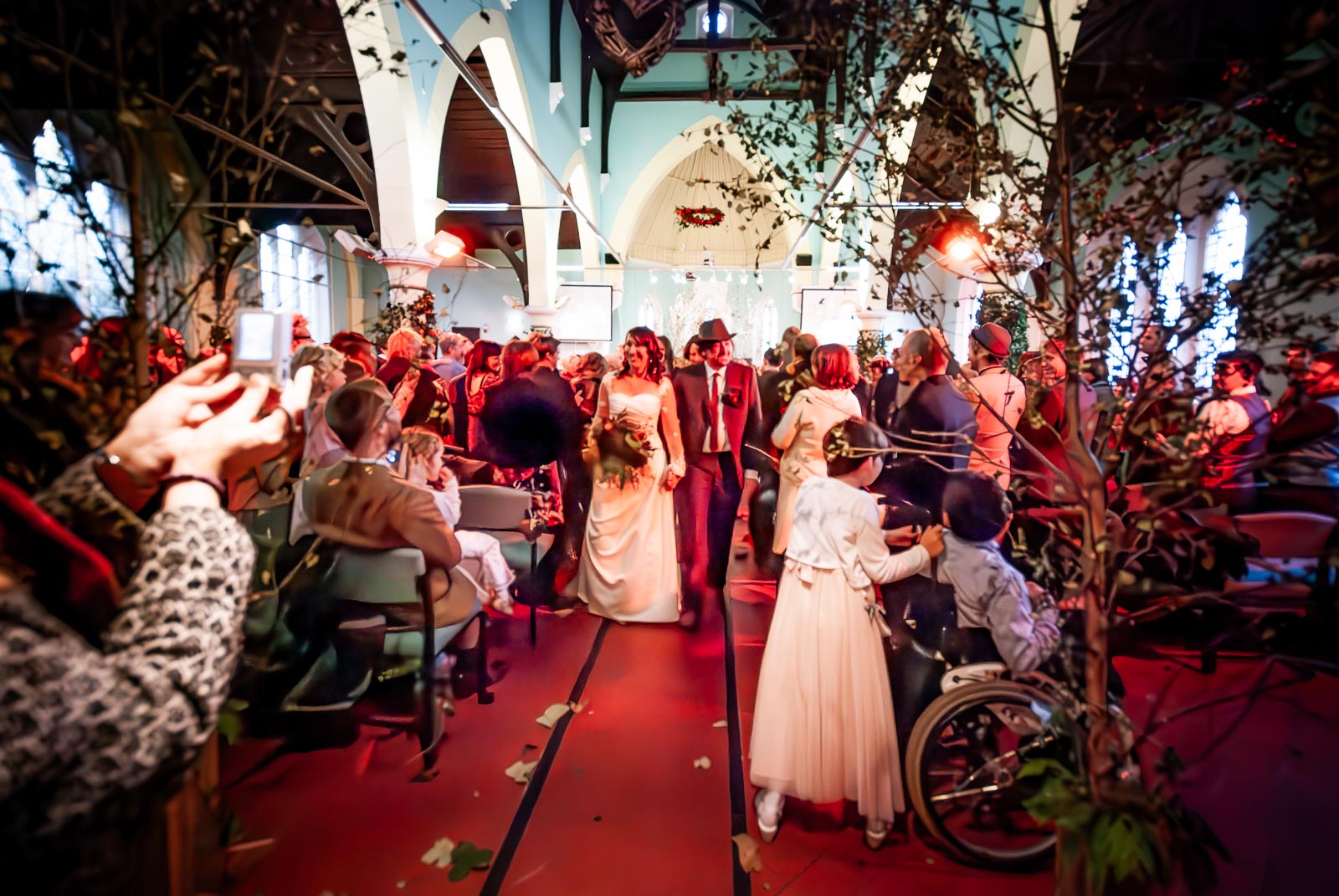 Jon and Lou walk through guests after their wedding at St Michaels Church in Brighton.