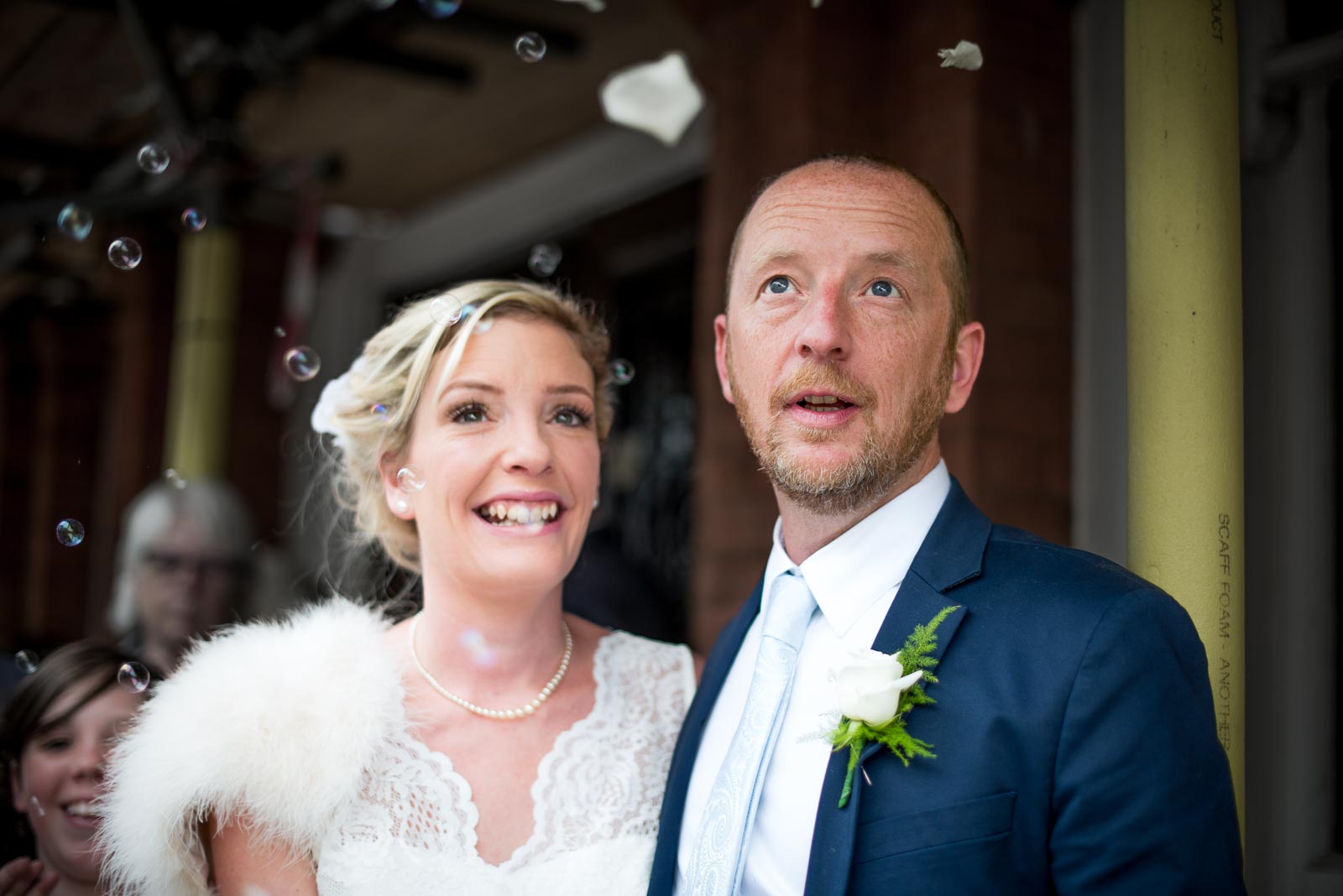 Emily and Richard look at bubble confetti outside Lewes Town Hall after their wedding.