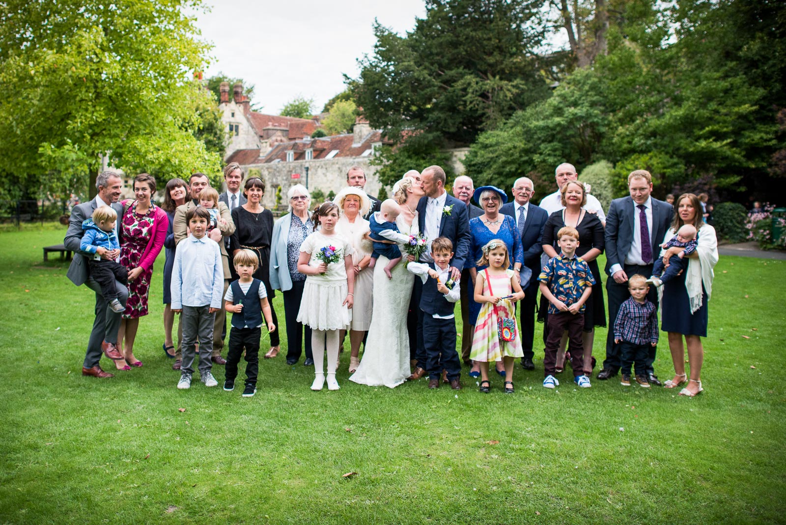 Emily and Richard pose with wedding guests in Southover Grange, Lewes