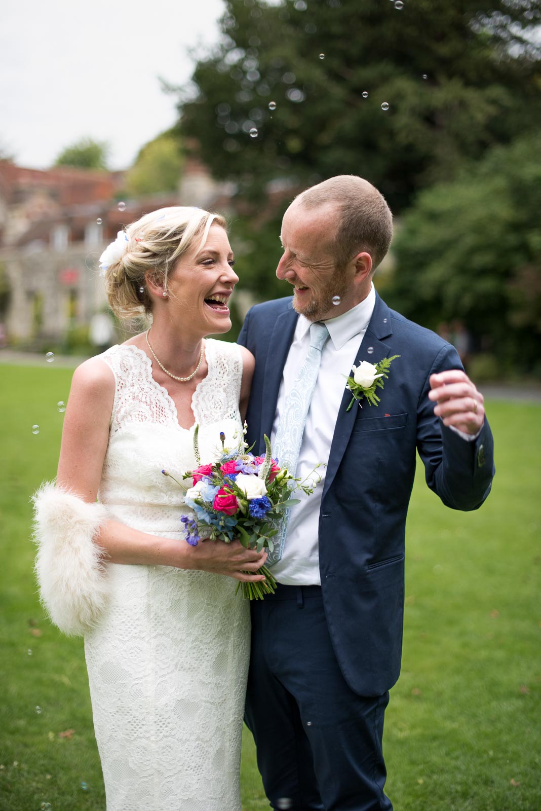 Emily and Richard laugh in Southover Grange, Lewes after their wedding.