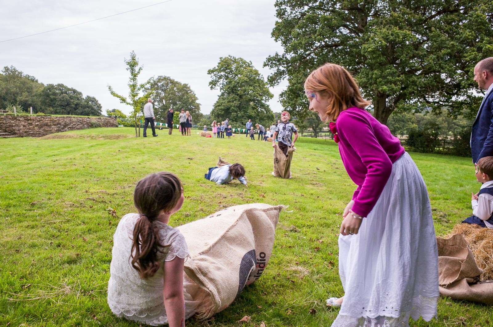 Wedding guests enjoy a sack race at Emily and Richard's wedding reception.
