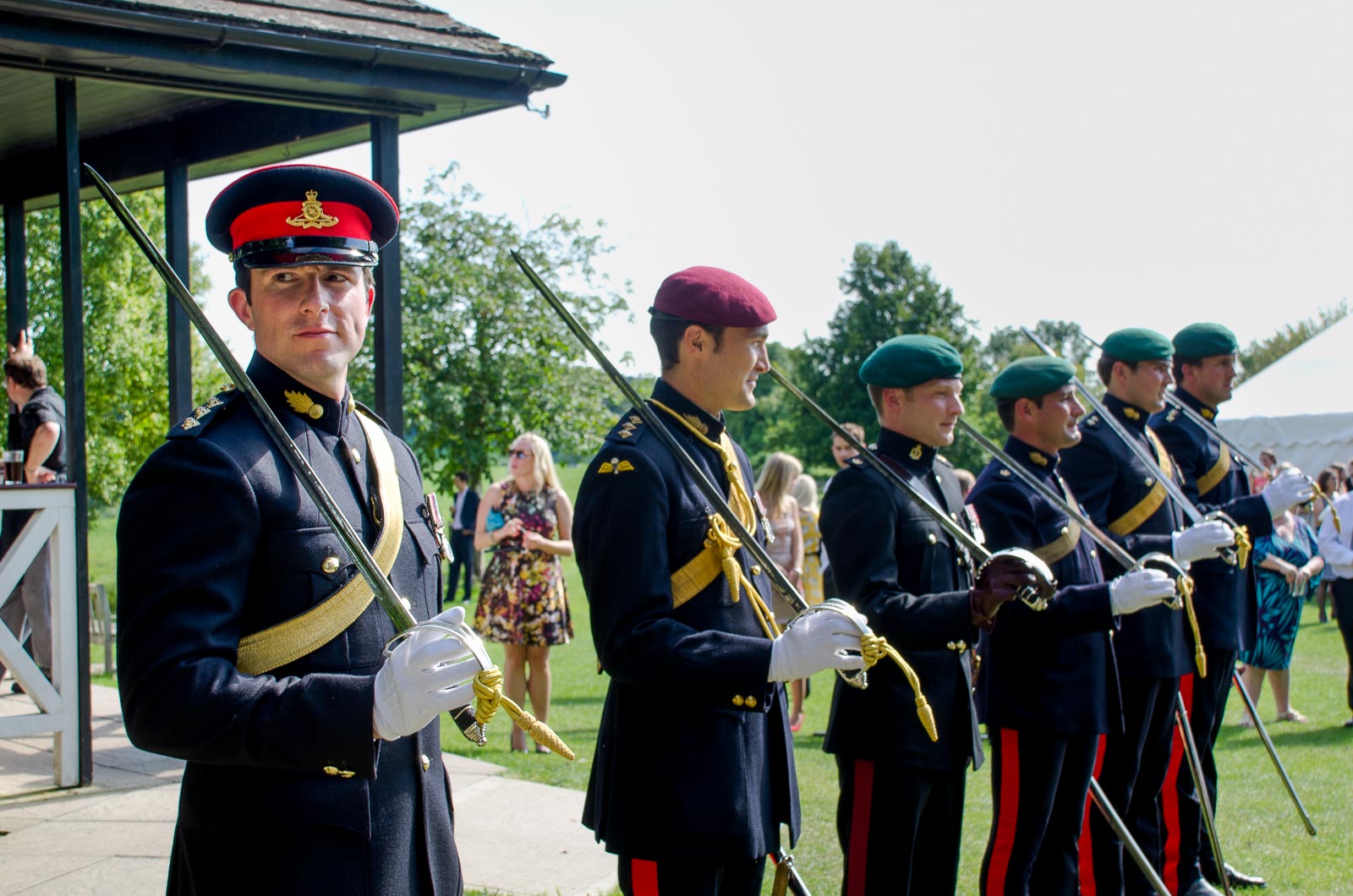 Members of the saber arch wait for Racael and Dan to arrive at their wedding reception at Burpham Village Hall.