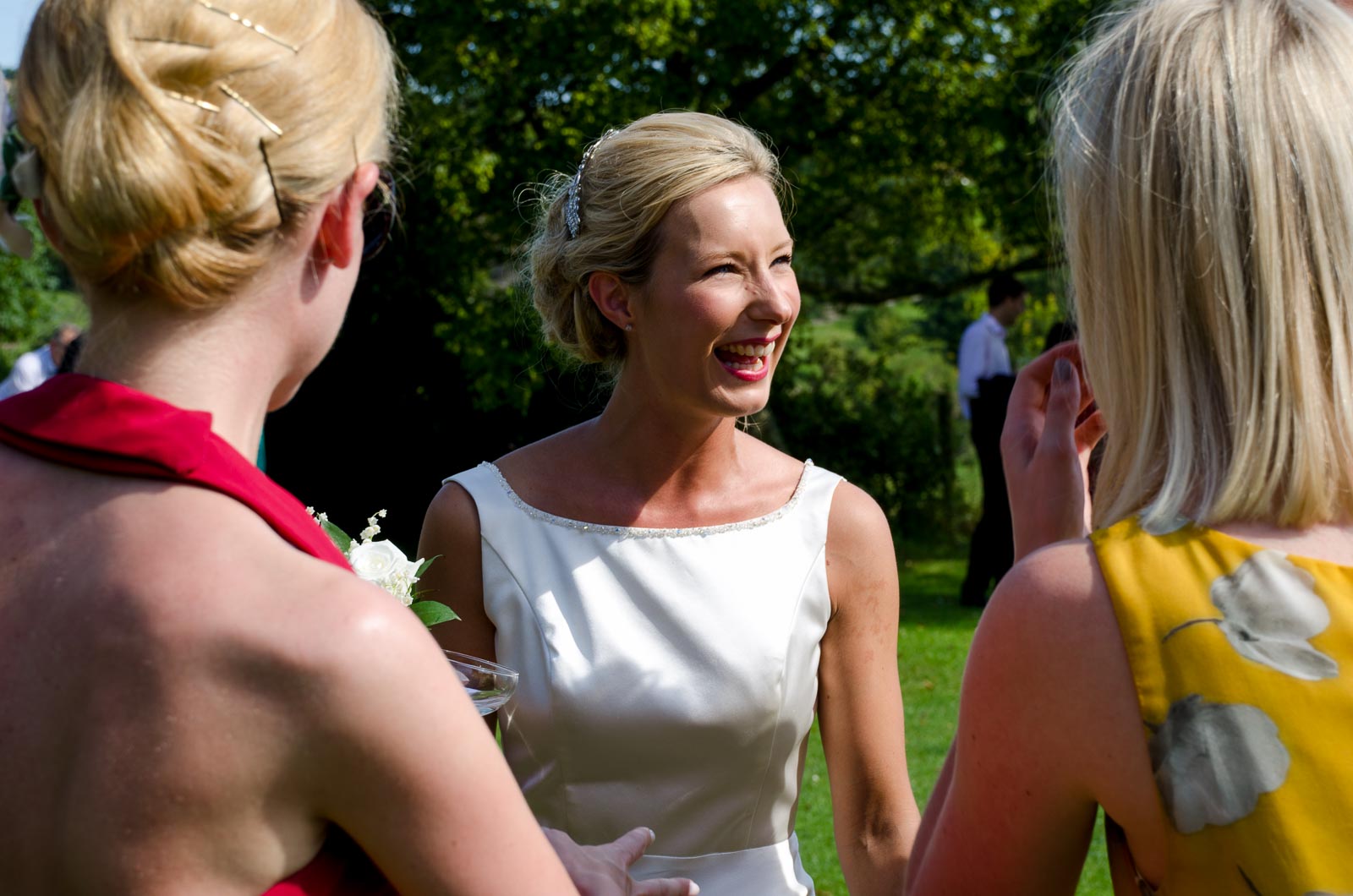 Rachael laughs with wedding guests at her wedding reception at Burpham Village Hall.