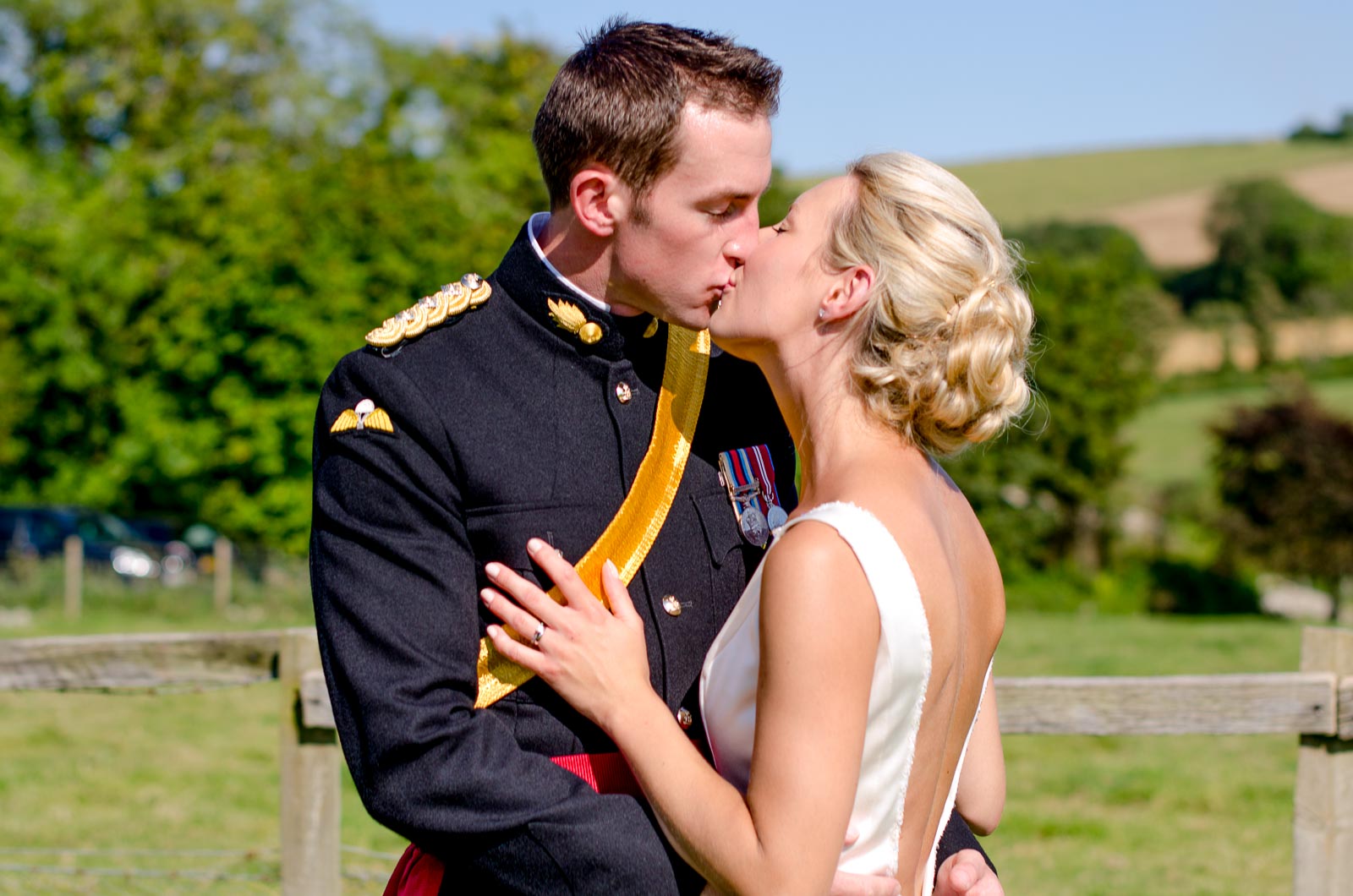 Rachael and Dan embrace on front of the South Downs during their wedding reception wedding reception at Burpham Village Hall.