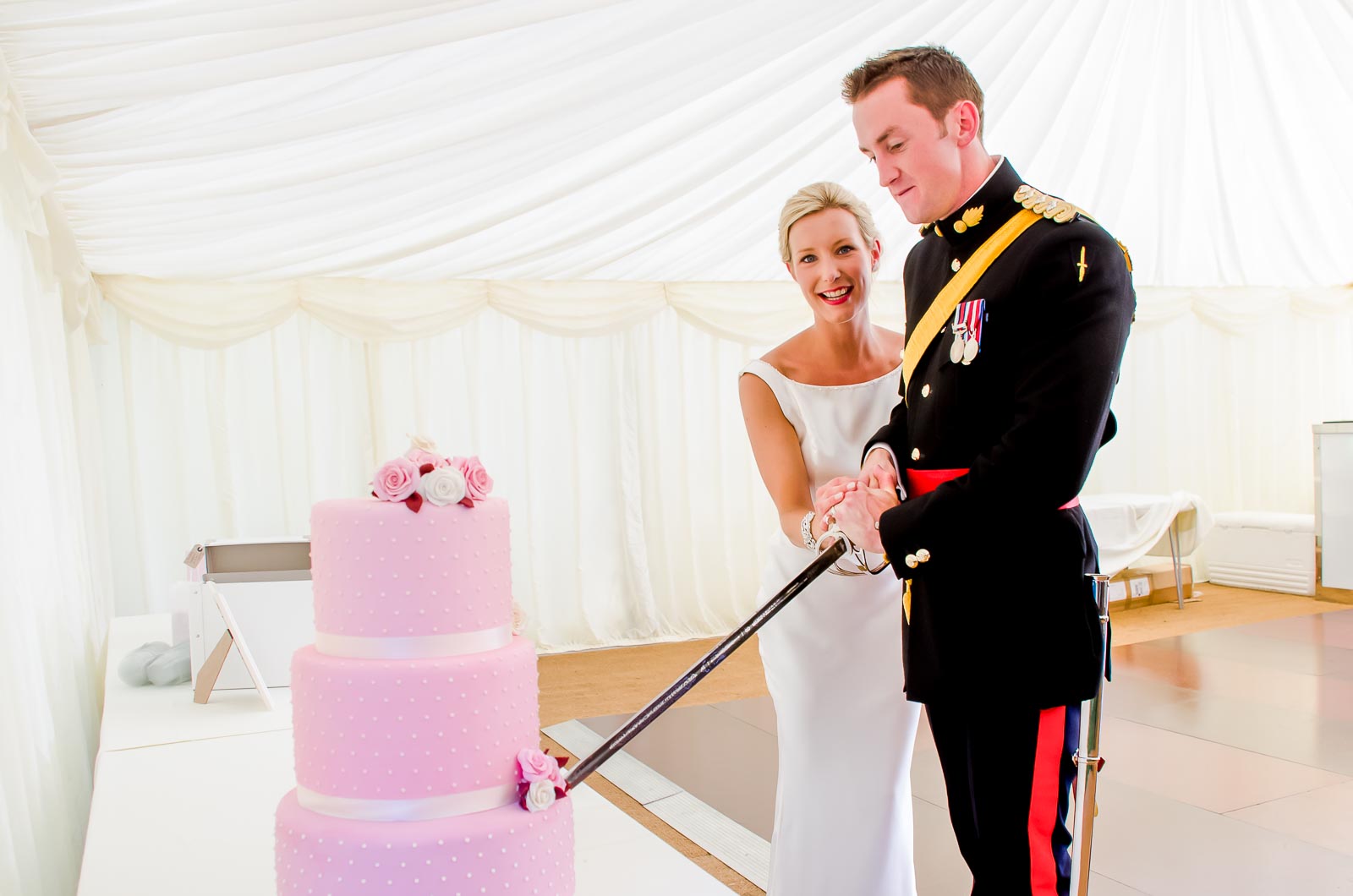 Rachael and Dan cut their wedding cake at their wedding reception wedding reception at Burpham Village Hall.