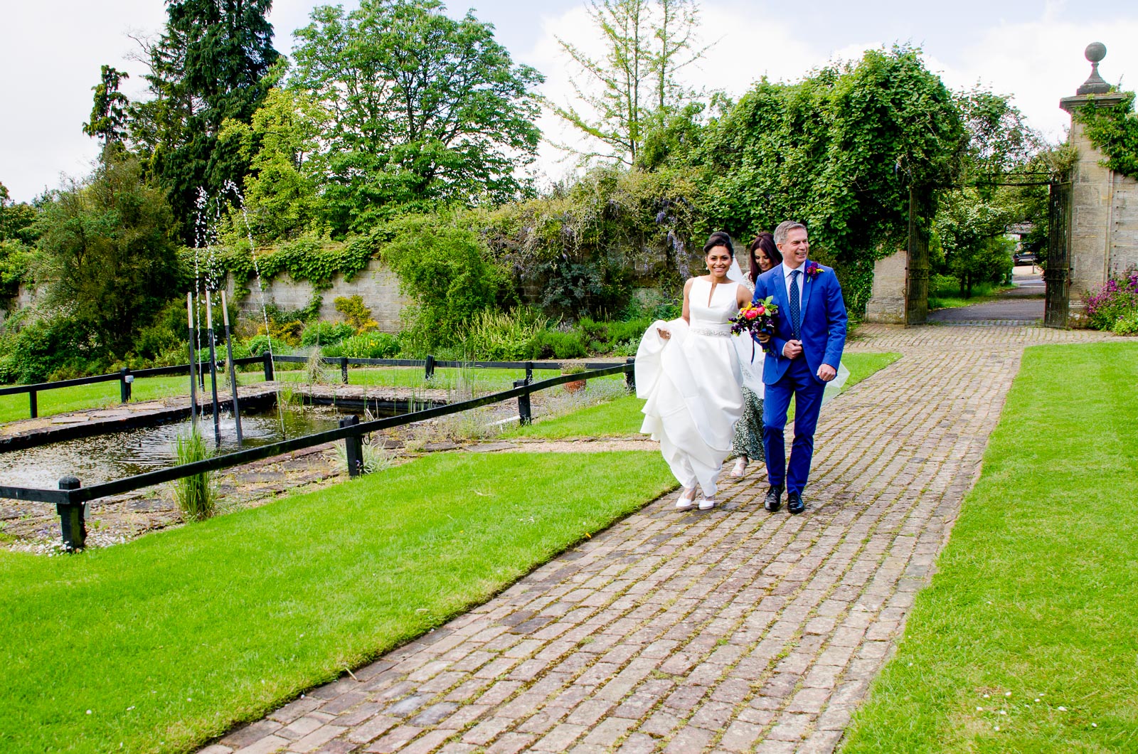 Tash is accompanied by her father on her way to her wedding reception in Borde Hill, Haywards Heath.