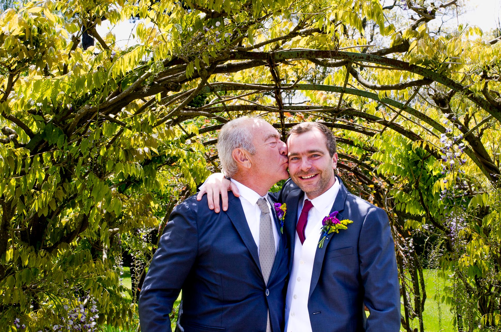 Raf and his dad pose in the gardens in Borde Hill, Haywards Heath under a leafy arch.