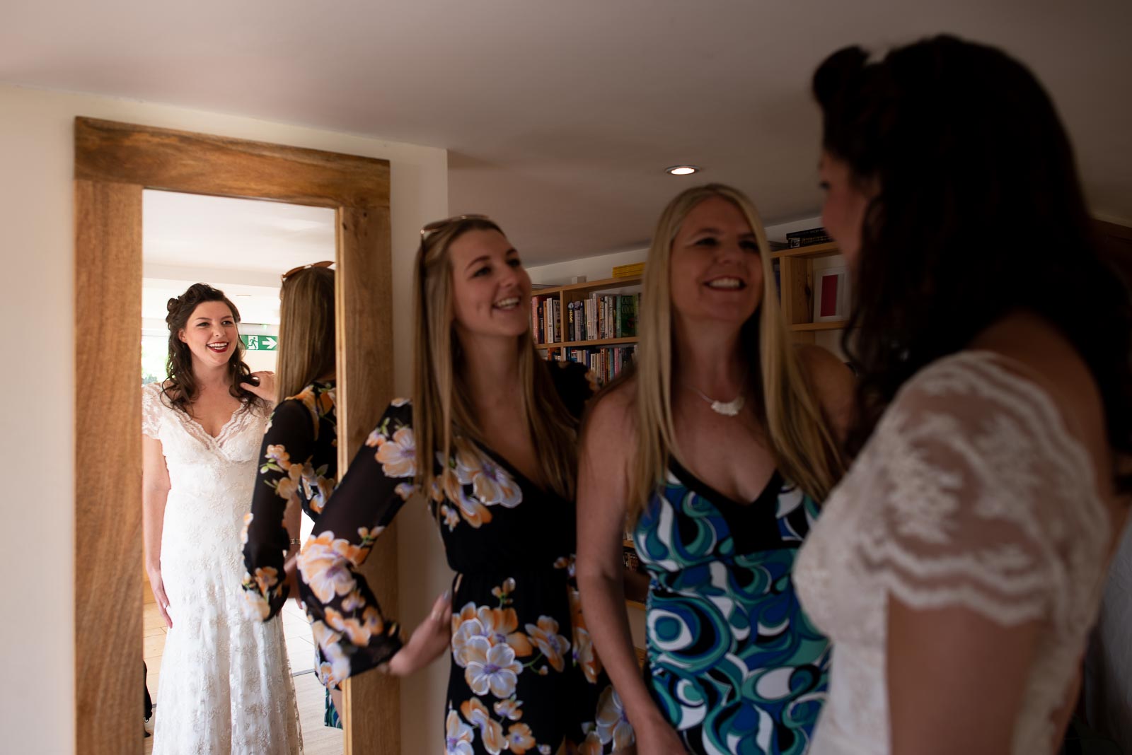 Toni looks at her self in a full length mirror and smiles in the farmhouse at Nutley Edge before her wedding.