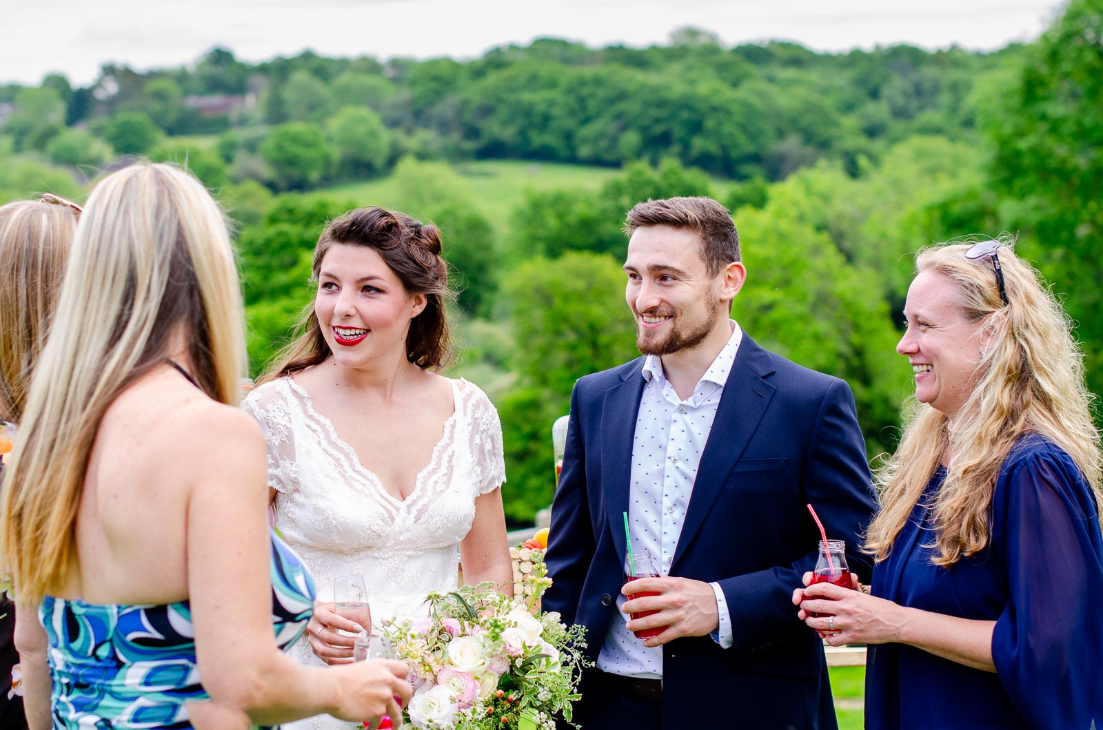 Toni, Luke and their wedding guests enjoy a drink at Nutley Edge with Ashdown Forest in the background.