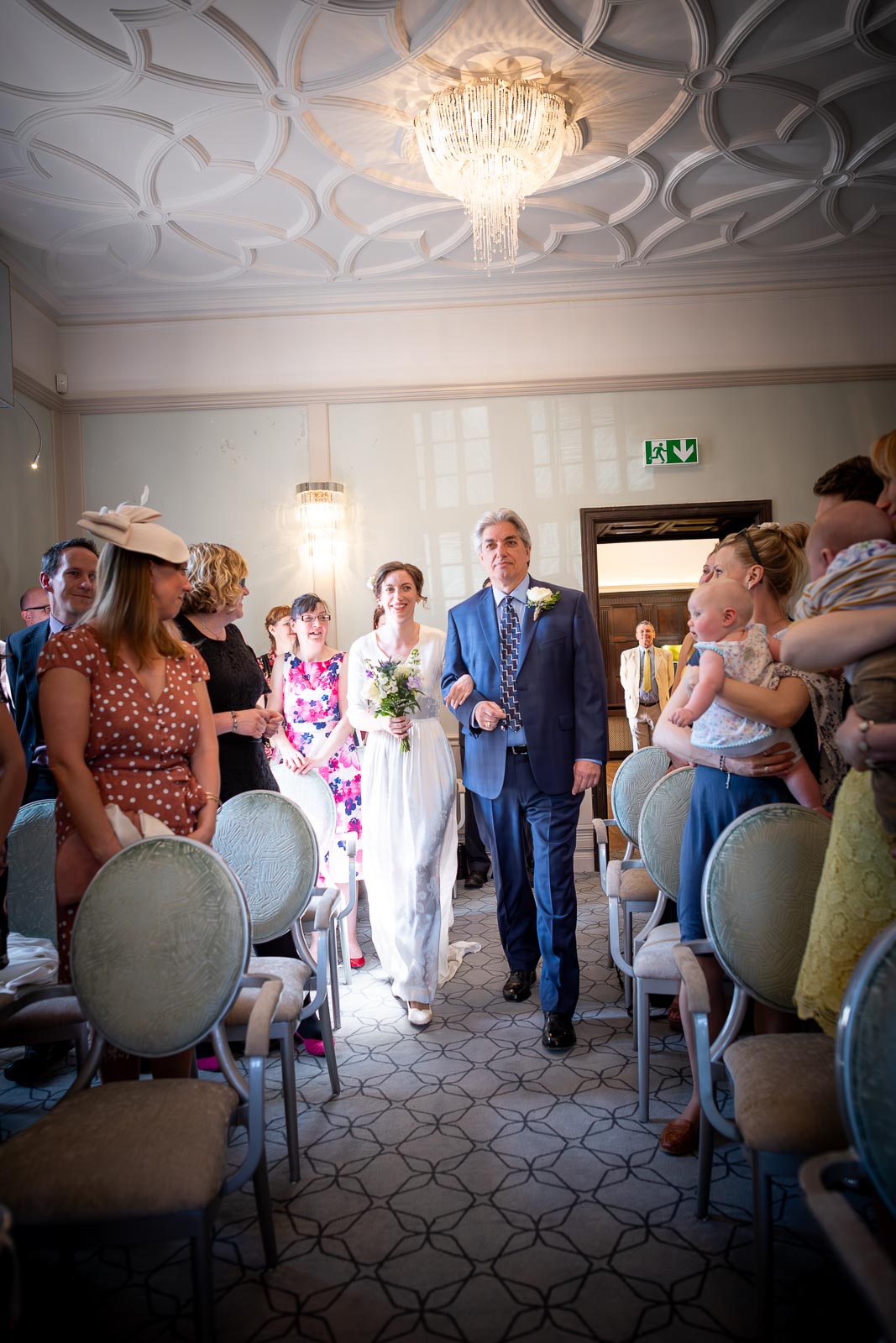 Alexis walks down the aisle accompanied by her Dad before her wedding in the Ainsworth Room at Lewes Registry Office before his wedding.