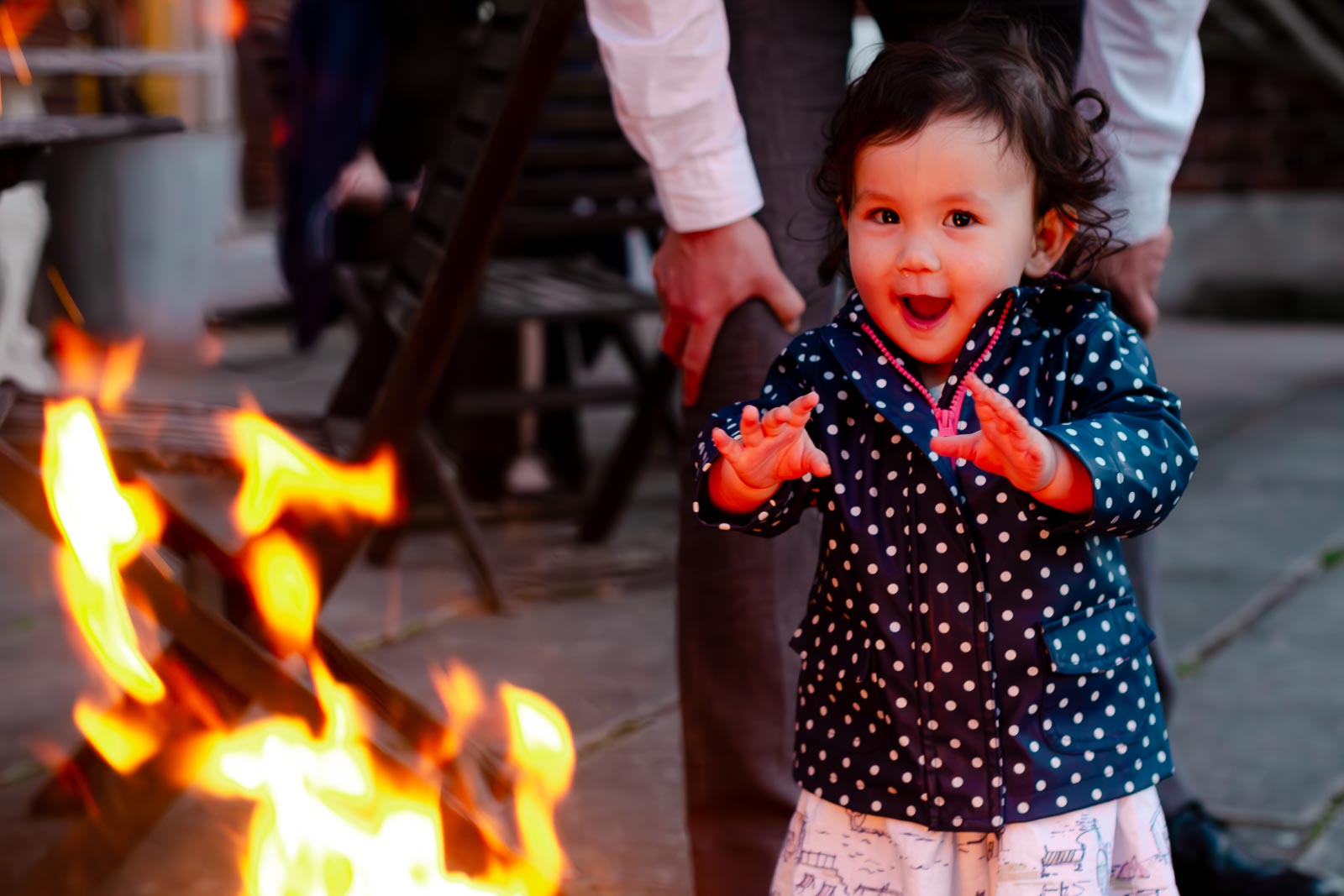 A young wedding guest enjoys the fire bowl in the garden of Pelham House Hotel, Lewes.