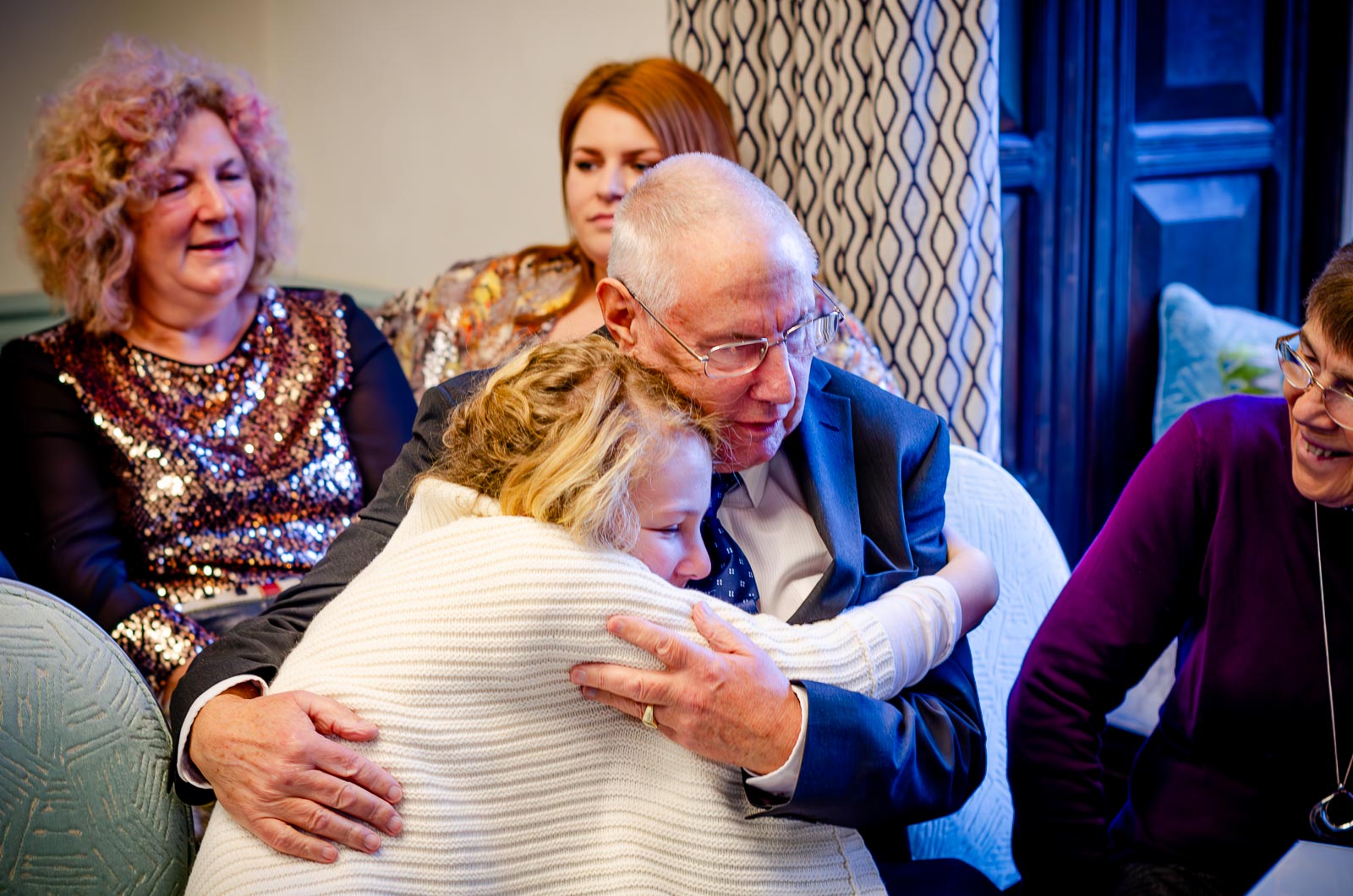 Wedding guests hug eachother in the Evelyn Room at Lewes Register Office before Grant and Jane's Wedding, 