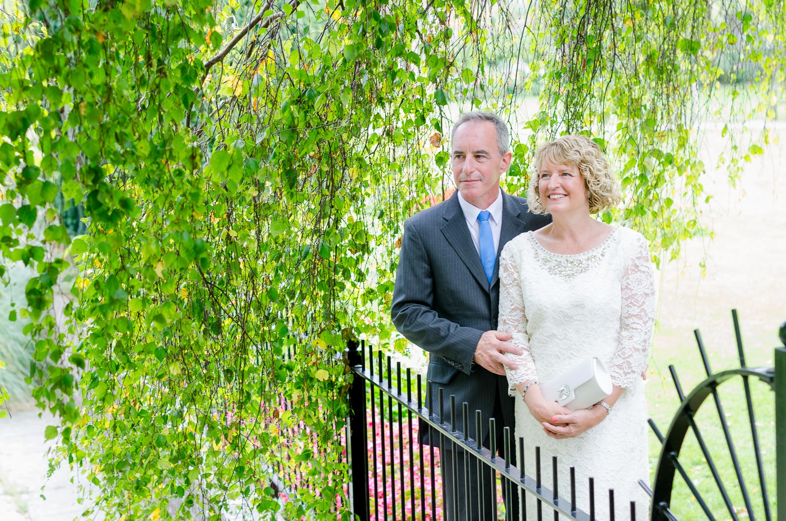 Wendy and Chris stand among trees in Southover Grange after their wedding at lewes Register Office.