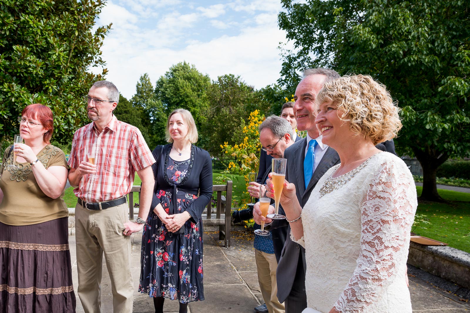 Wendy and Chris hold wine glasses in Southover Grange after their wedding at lewes Register Office.