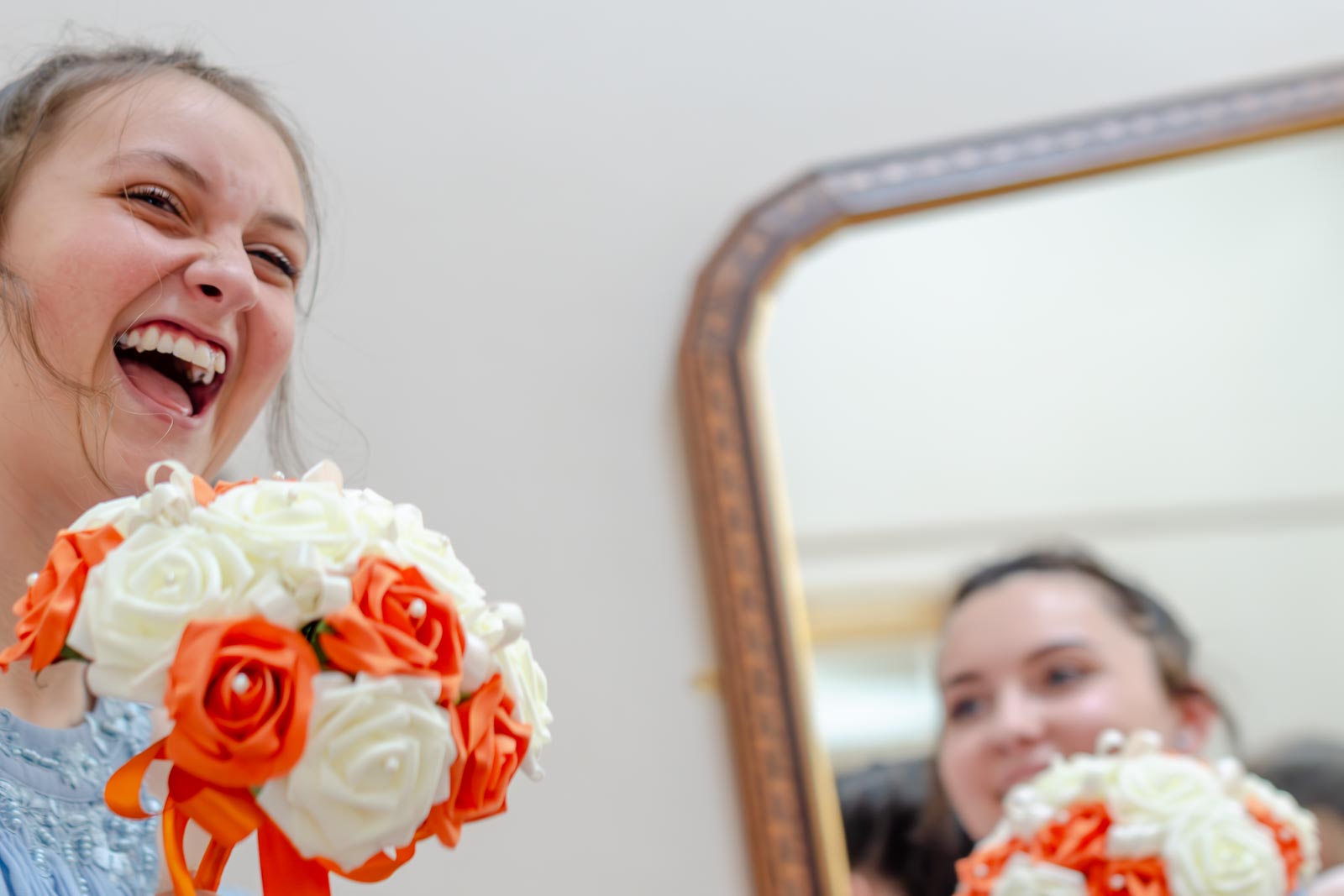 Bridemaids laugh on front of a mirror on the stairs at The Shelley's Hotel in Lewes.