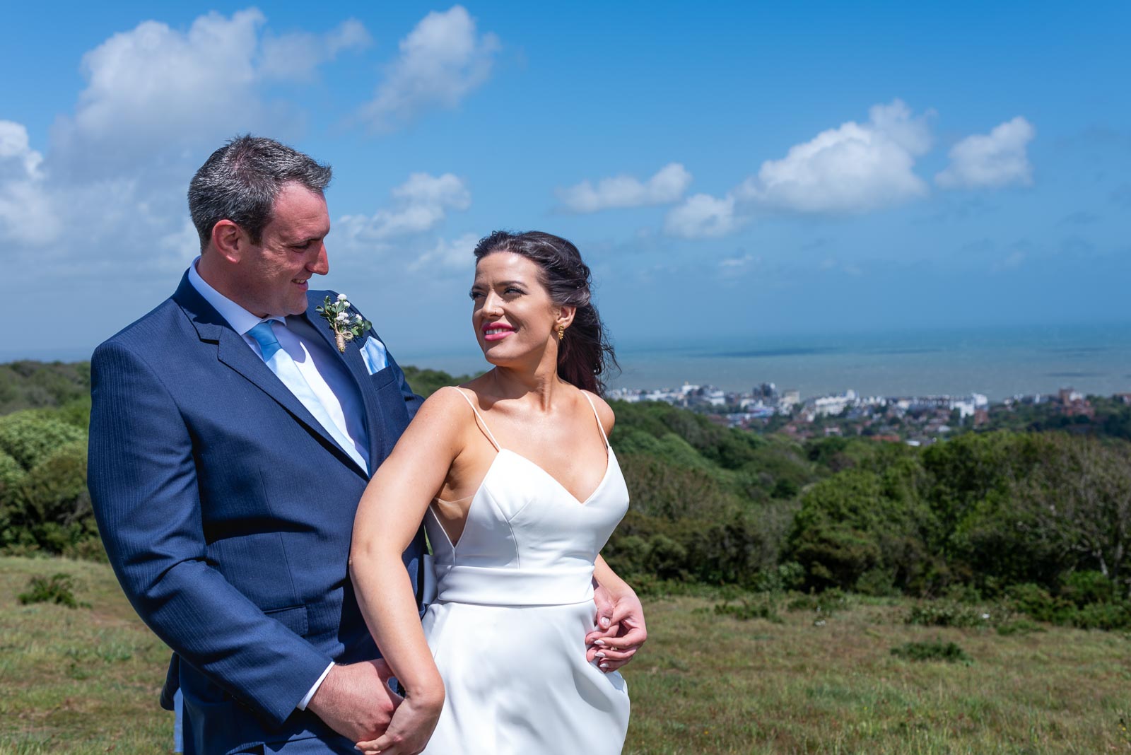 Ally and Jane enjoy some blustery winds on top of beachy head after their wedding at Grand Hotel, Eastbourne.