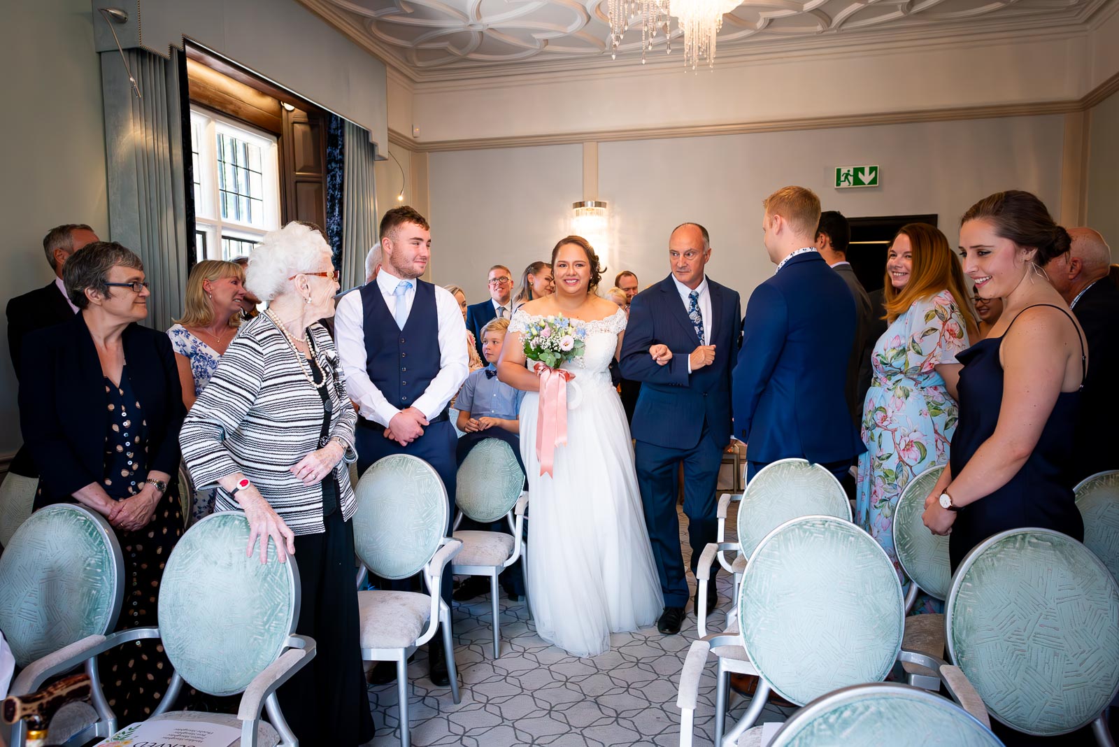 Amy walks down the aisle in the Ainsworth Room in Lewes Register Office with her father before her wedding to James.