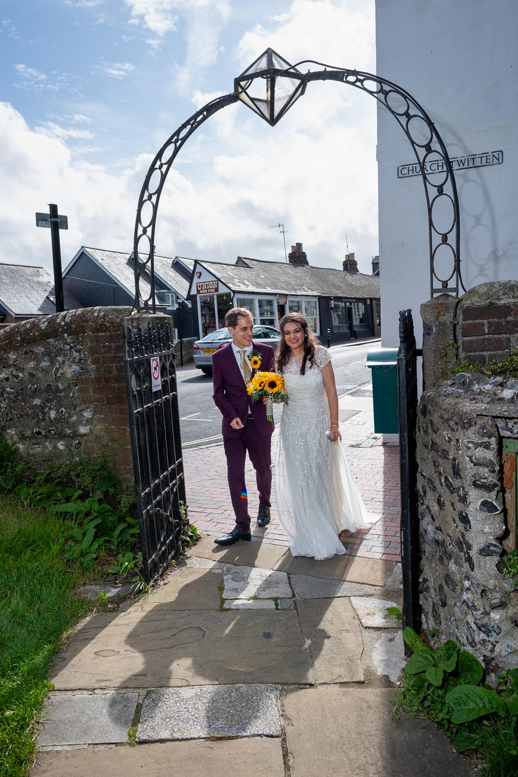 Ashley and Anjana walk in the front gate at Lewes All Saints Centre before their Wedding Reception.