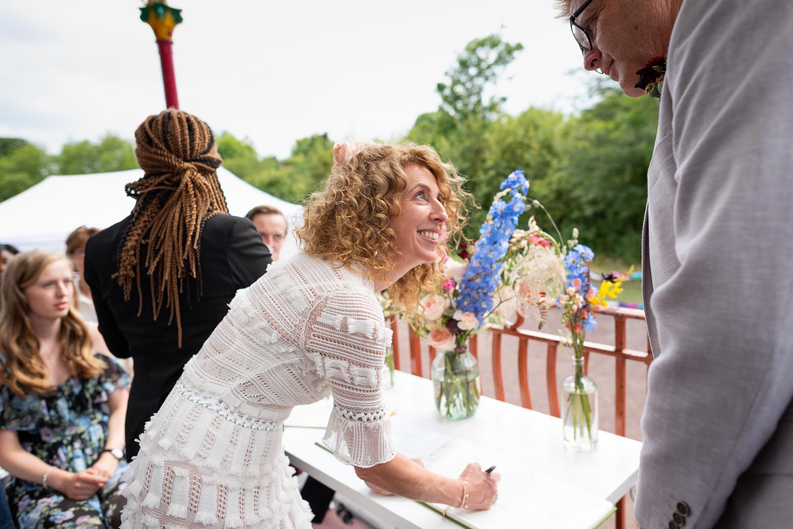 Kitty and Will sign the wedding register during their ceremony in the Band Stand at Queens Park in London.