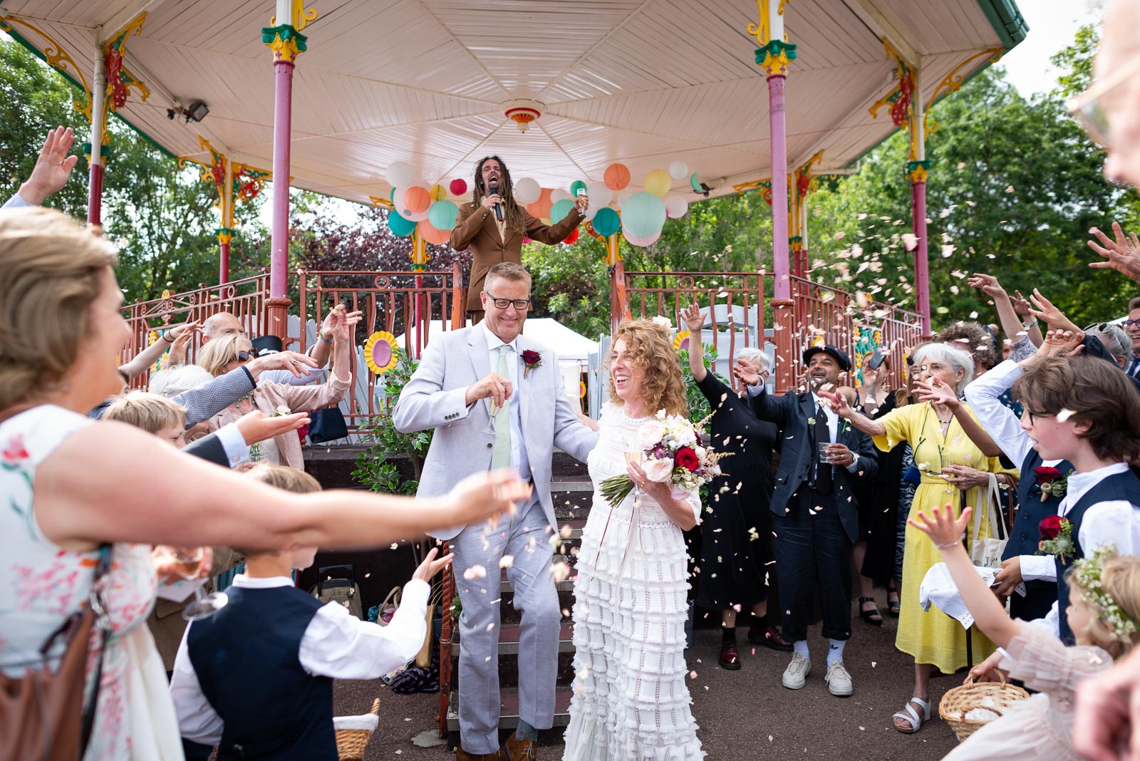 Wedding guests throw confetti over Kitty and Will after their ceremony in the Band Stand at Queens Park in London.