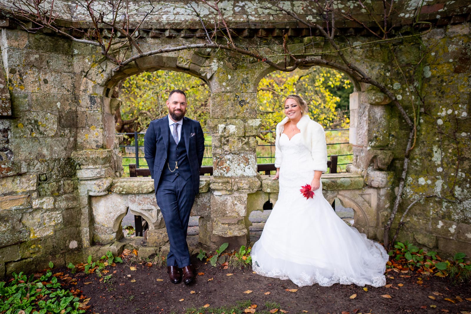 Laura and Sam pose in the arches in Southover Grange, Lewes after their wedding. 