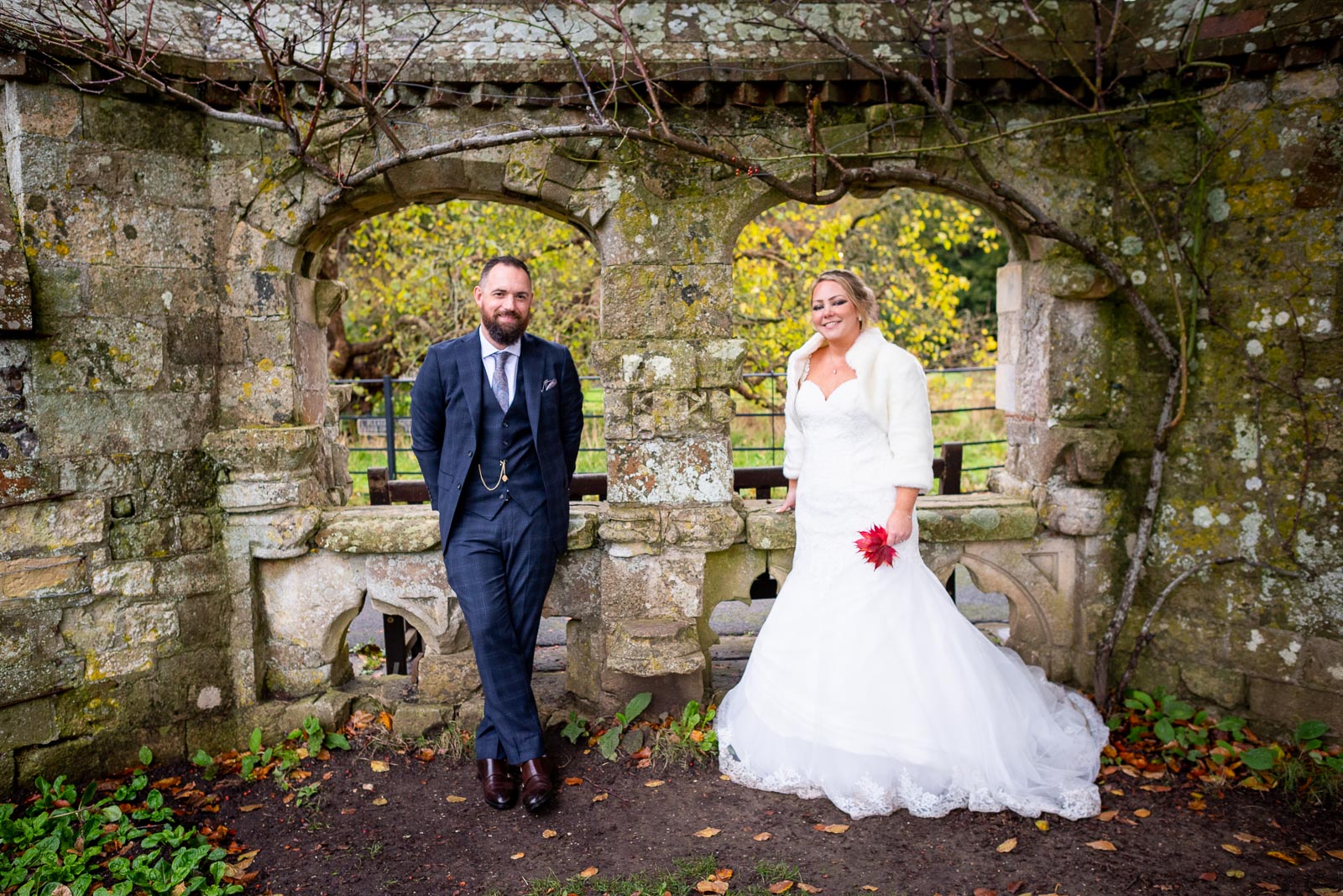 Laura and Sam pose in the arches in Southover Grange, Lewes after their wedding. 