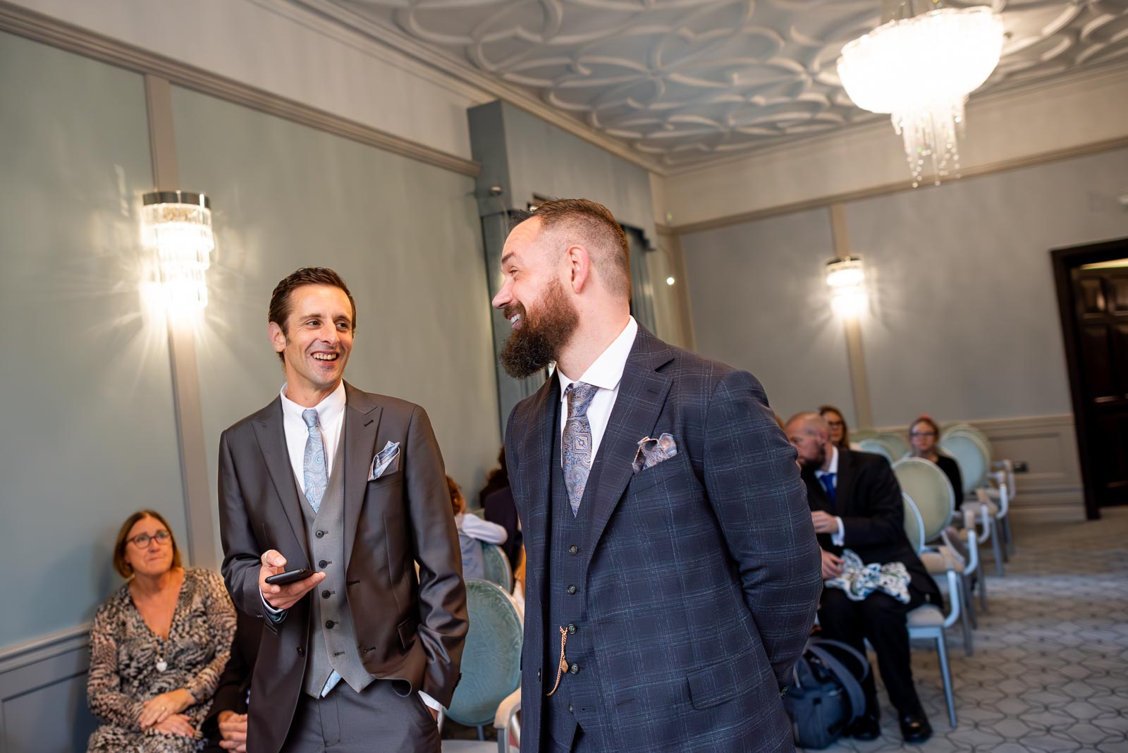 Sam and his best man smile at the top of the aisle in the Ainsworth Room in Lewes Register Office before Sam's wedding to Laura.