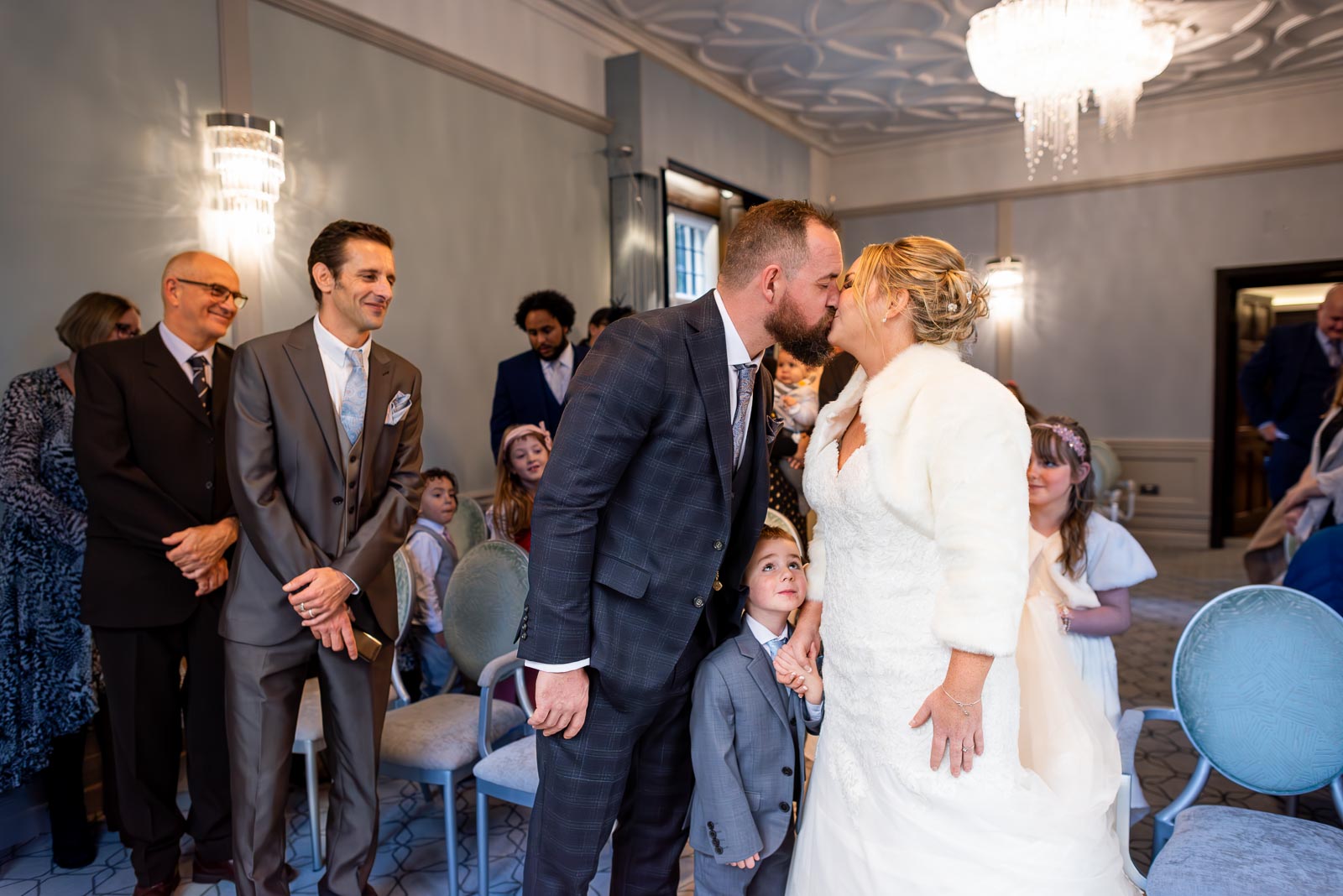 Laura and Sam embrace at the top of the aisle in the Ainsworth Room in Lewes Register Office before they wedding.