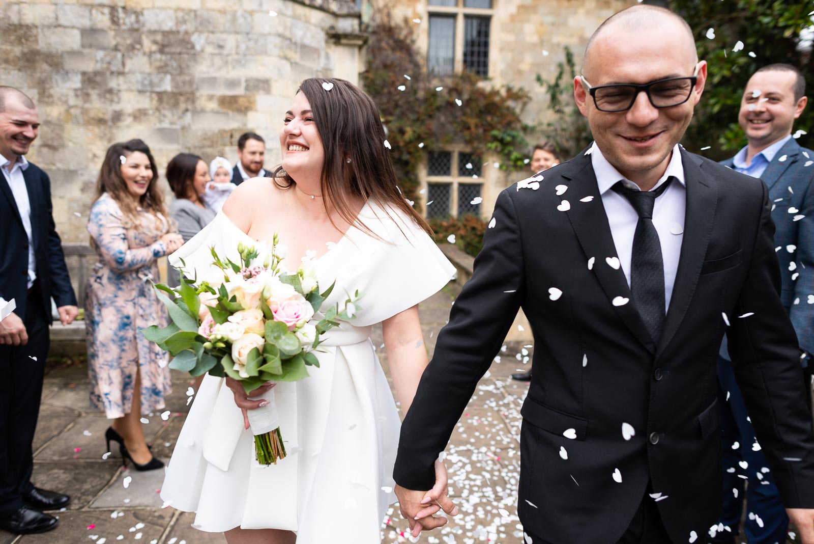 Guests throw confetti outside Lewes Register Office over Robert and Maria after their wedding.