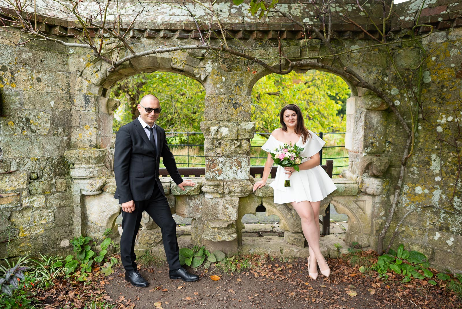 Maria and Robert pose in the arches in Southover Grange, Lewes after their wedding. 