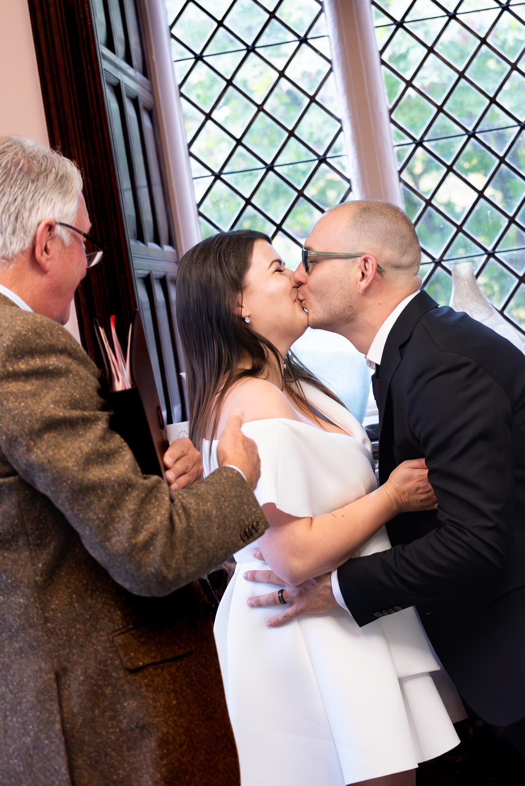 Maria and Robert embrace in the Evelyn room at Lewes Register Office after their wedding.