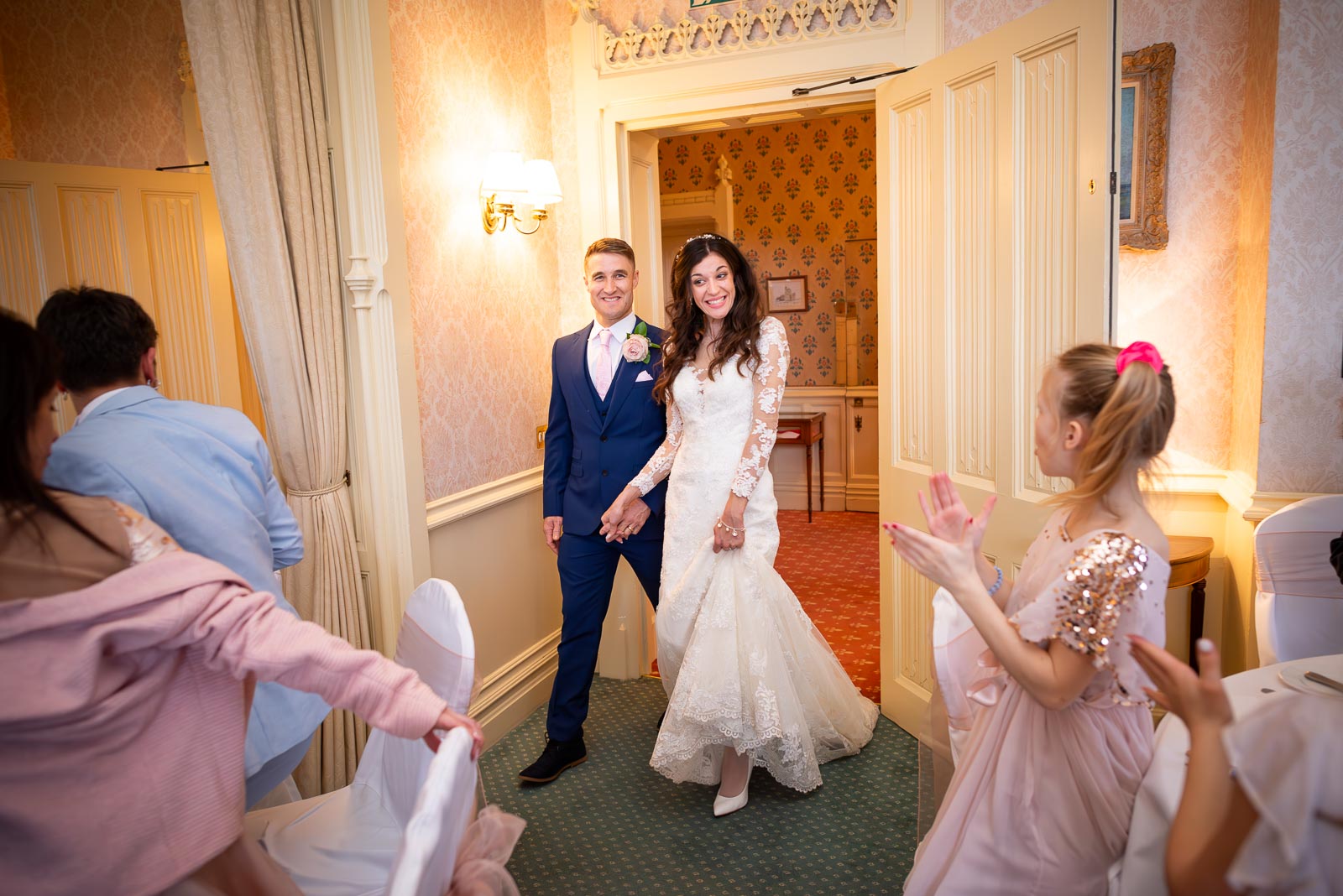 Virginia and Simon are greeted by their guests on arriving at their wedding breakfast at Horsted Place. 