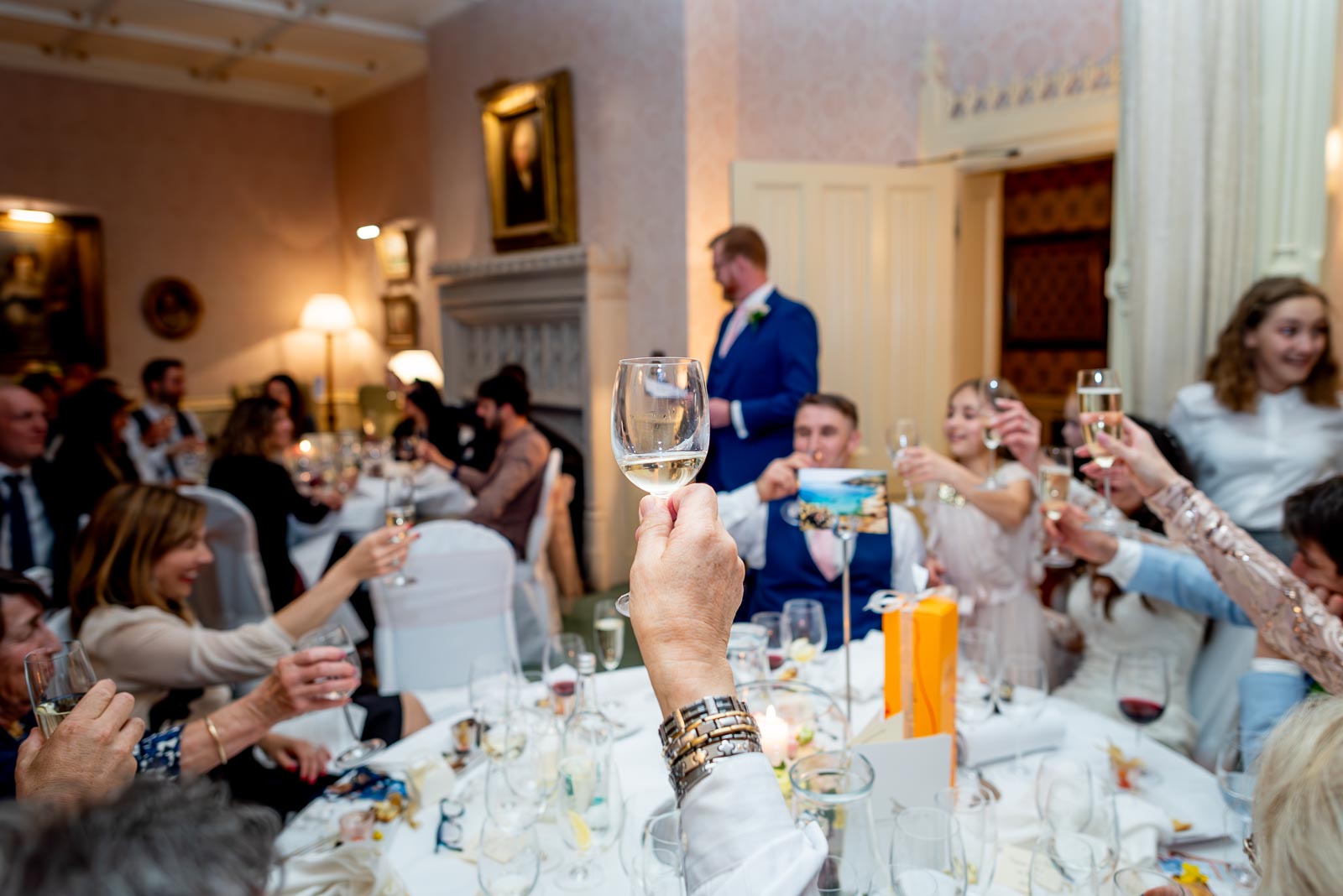 Wedding guests toast the bride and grrom during their Wedding Reception at Horsted Place Hotel.