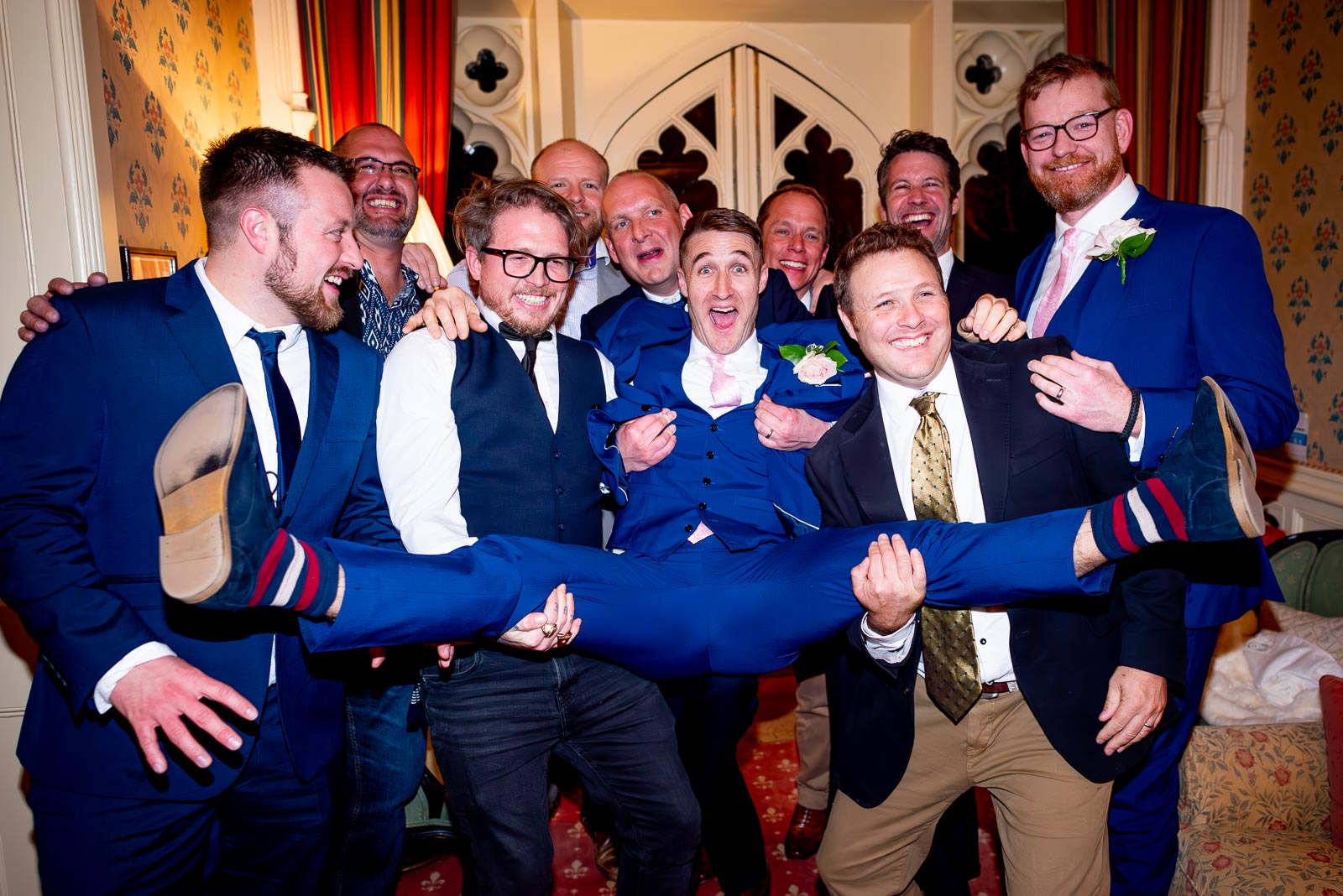 Simon's groomsmen lift him in a funny pose during Simon and Virginia's wedding reception at Horsted Place Hotel.