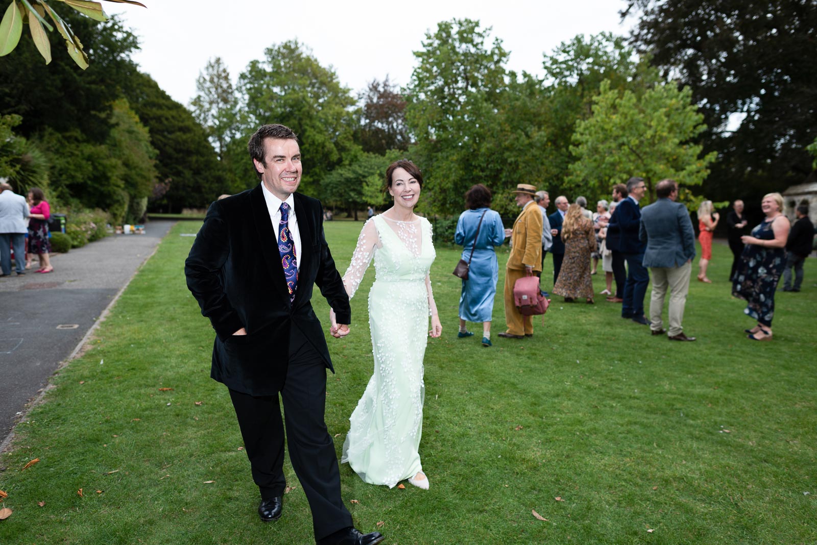 Fiona and Richard walk past their guests in Southover Grange, Lewes after their wedding.