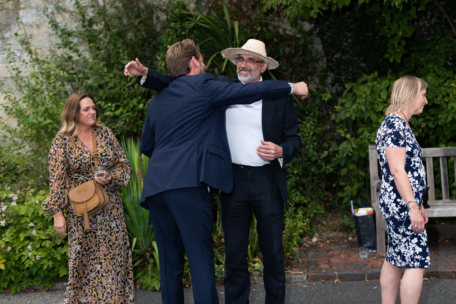 Guests embrace at Fiona and Richard's wedding in Southover Grange, Lewes.