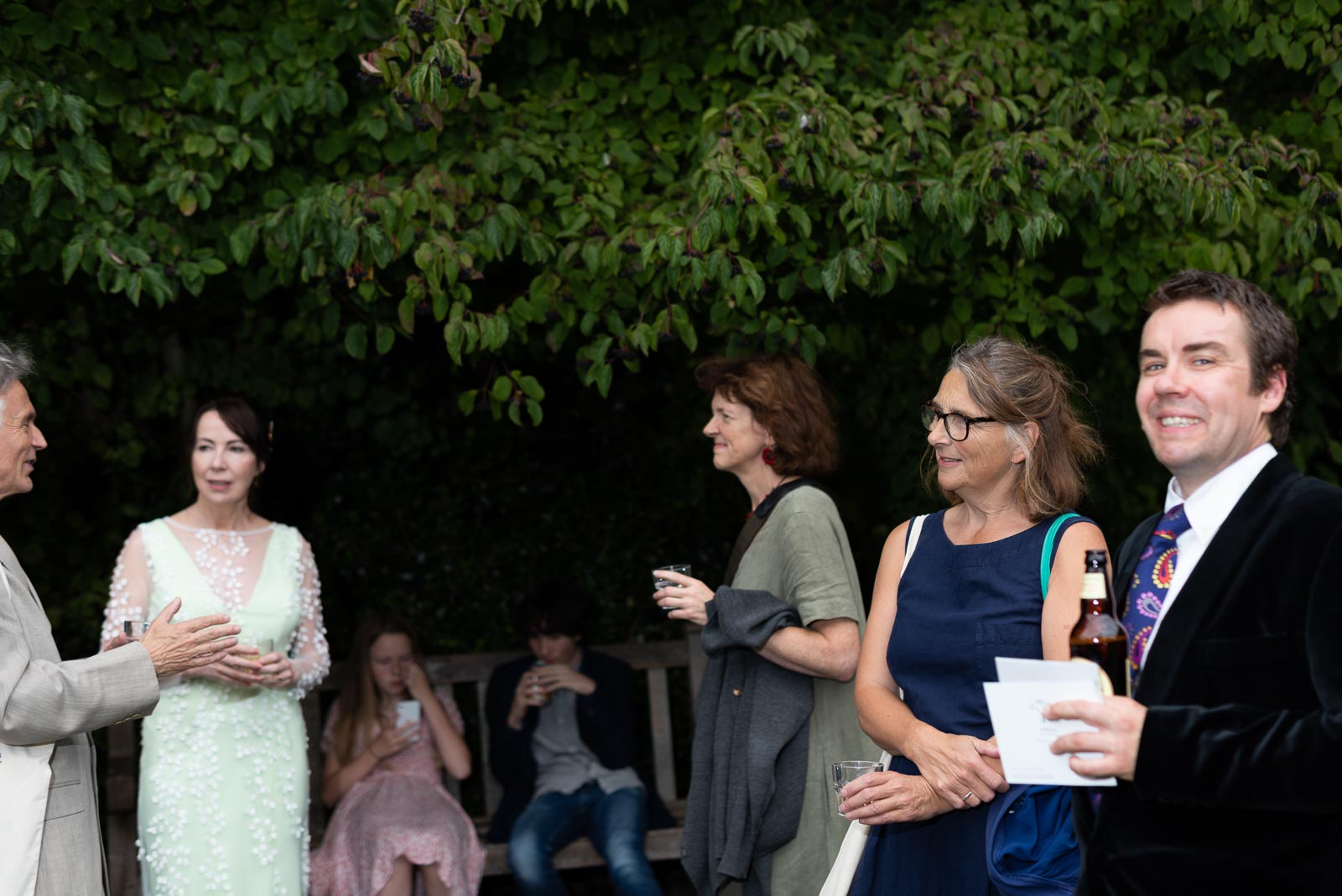 Guests chat at Fiona and Richard's wedding in Southover Grange, Lewes.