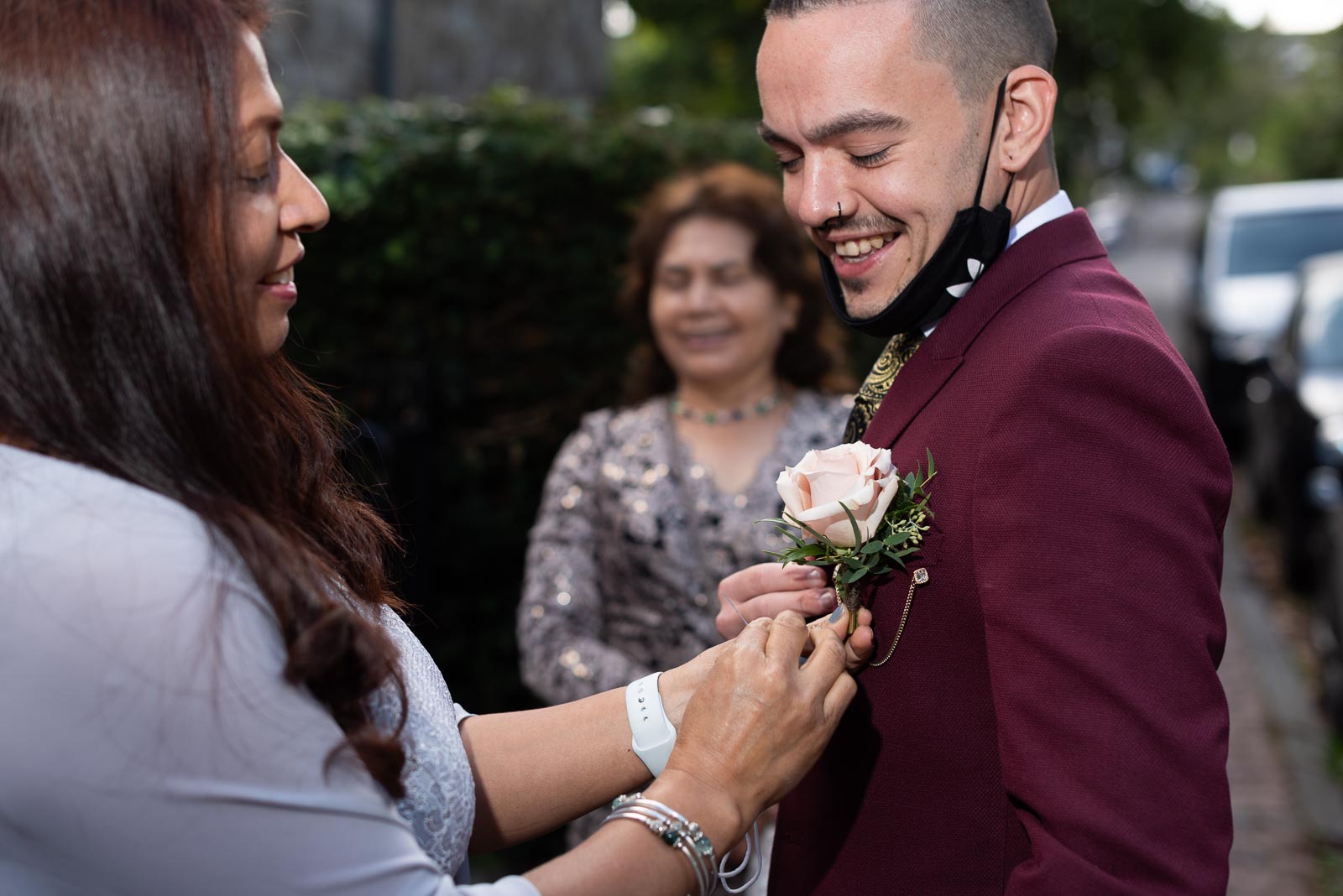 Ady's soon to be mother in law attaches a wedding pin to his lapel outside Lews Registry Office. 