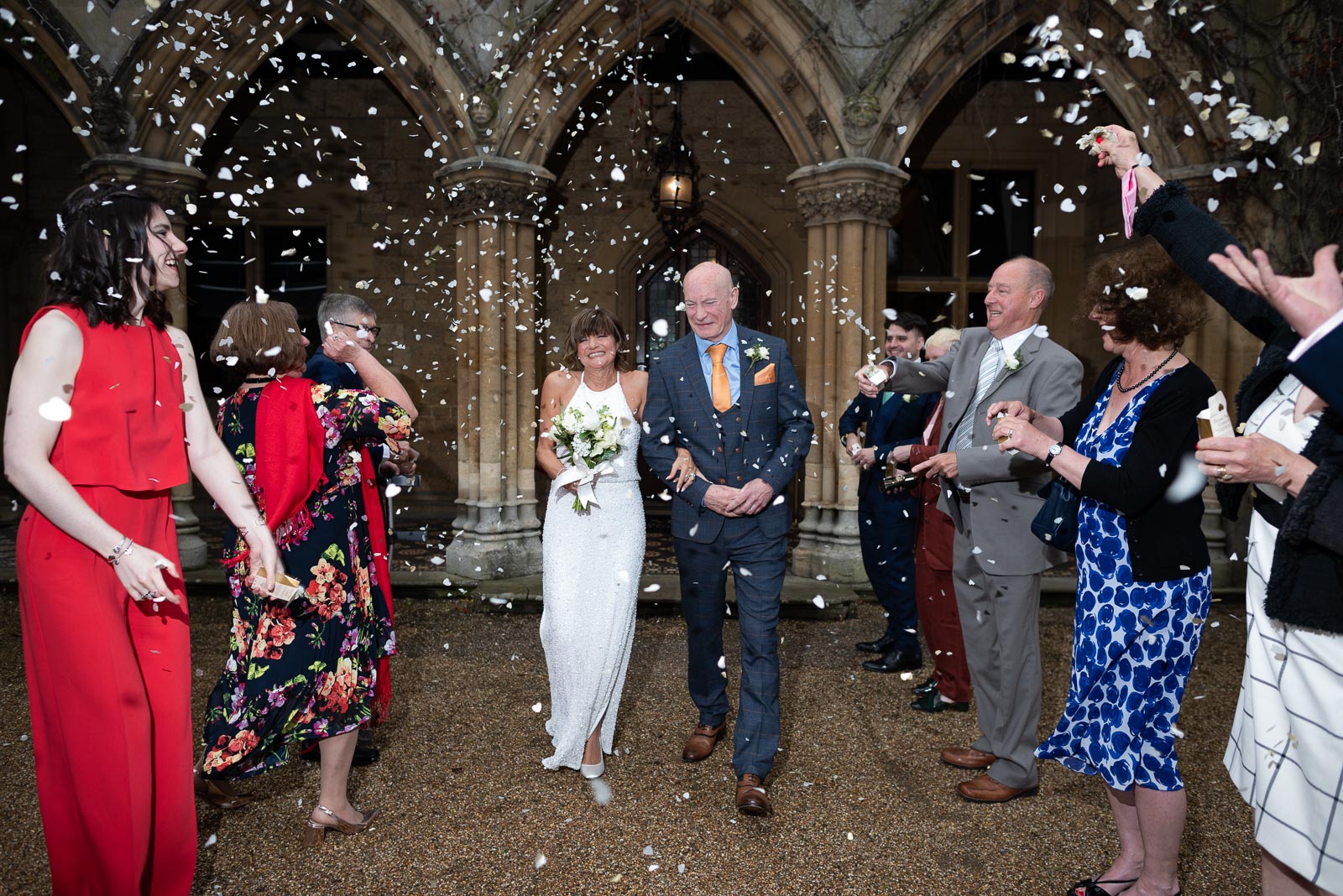 Carmen and Jeff walk through confetti thrown by their family and friends outside Manor by the Lake in Cheltenham