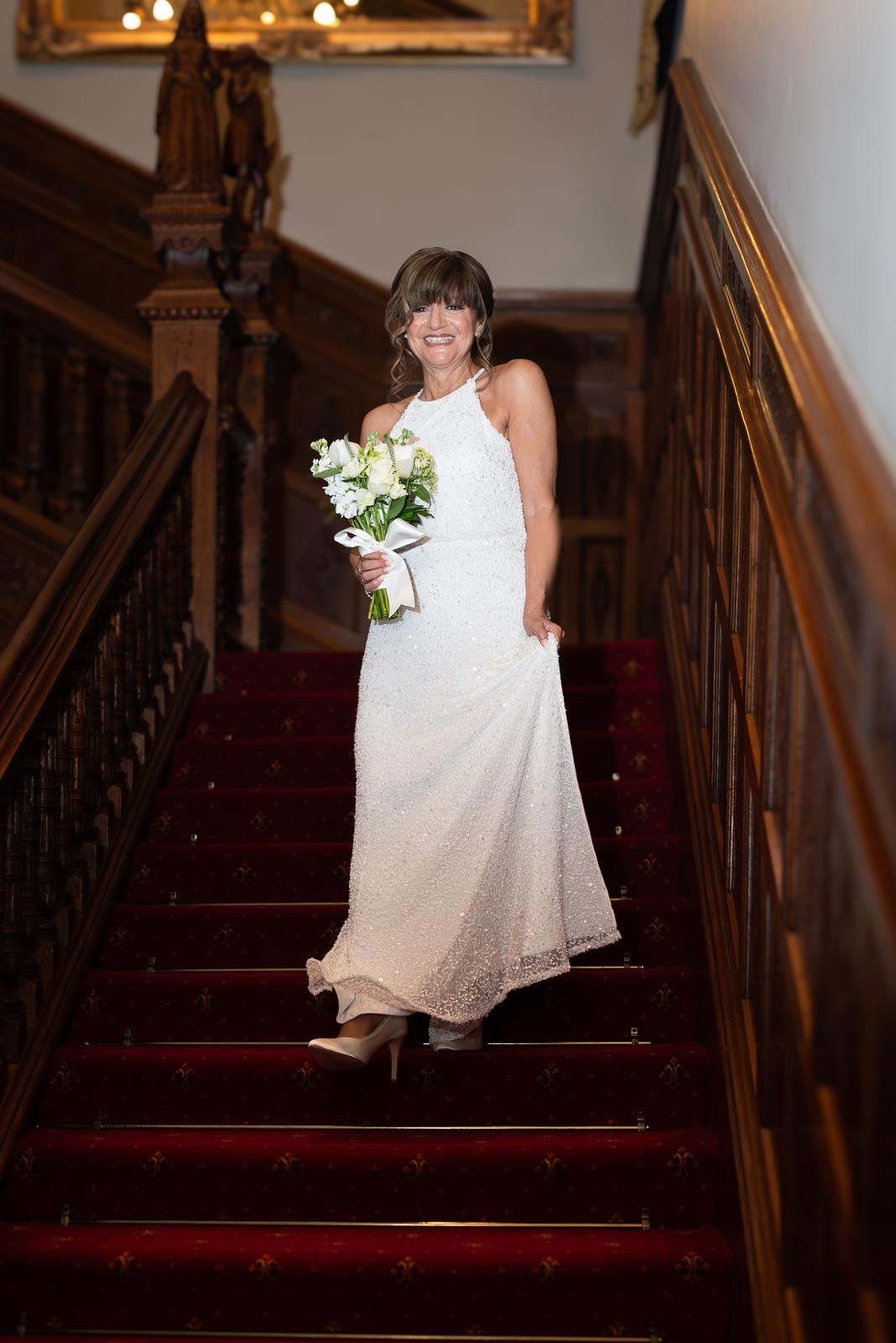 Carmen descends down the stairs at Manor by the Lake in Cheltenham before her wedding to Jeff.