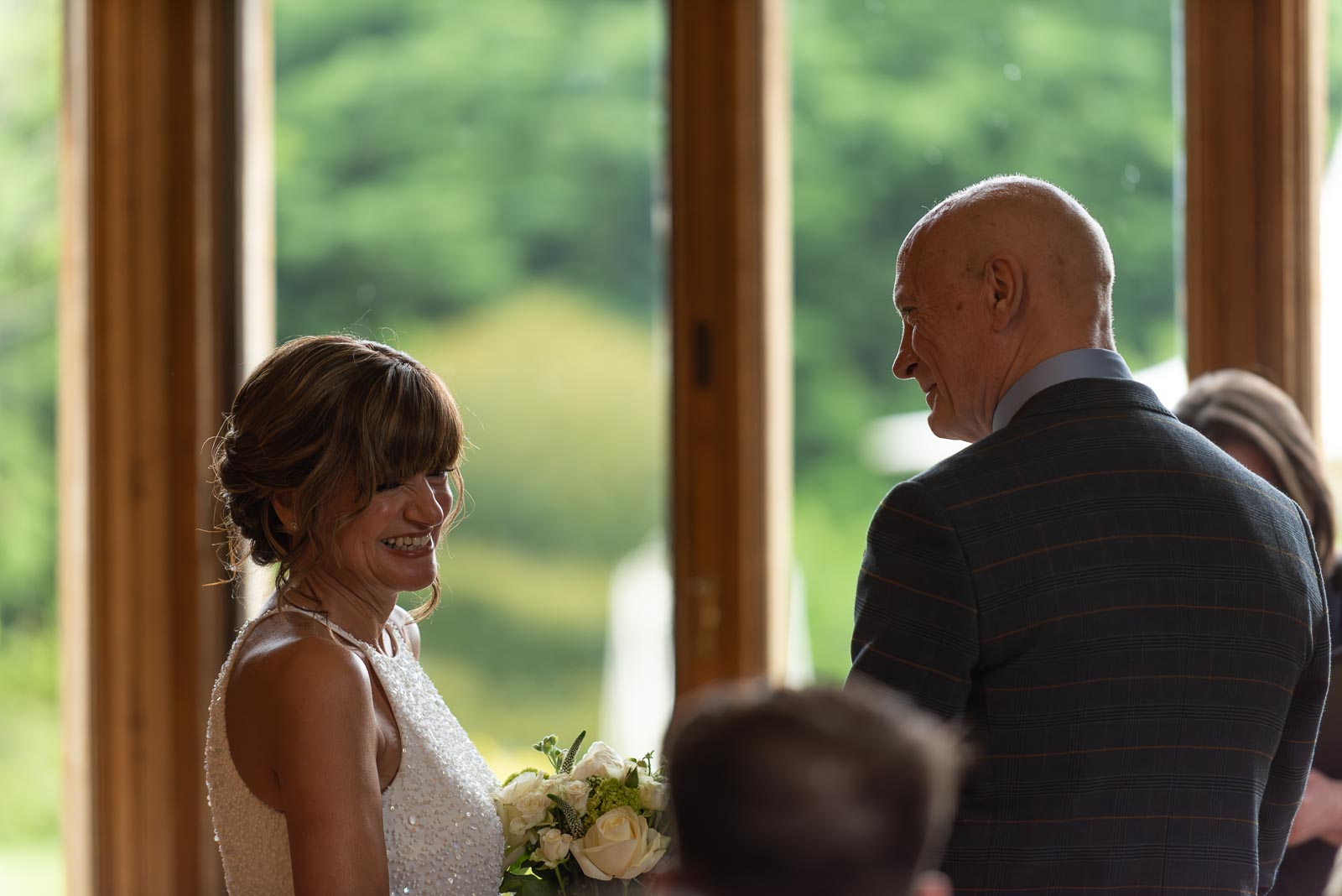 Carmen smiles at Jeff beofre their wedding at Manor by the Lake in Cheltenham.