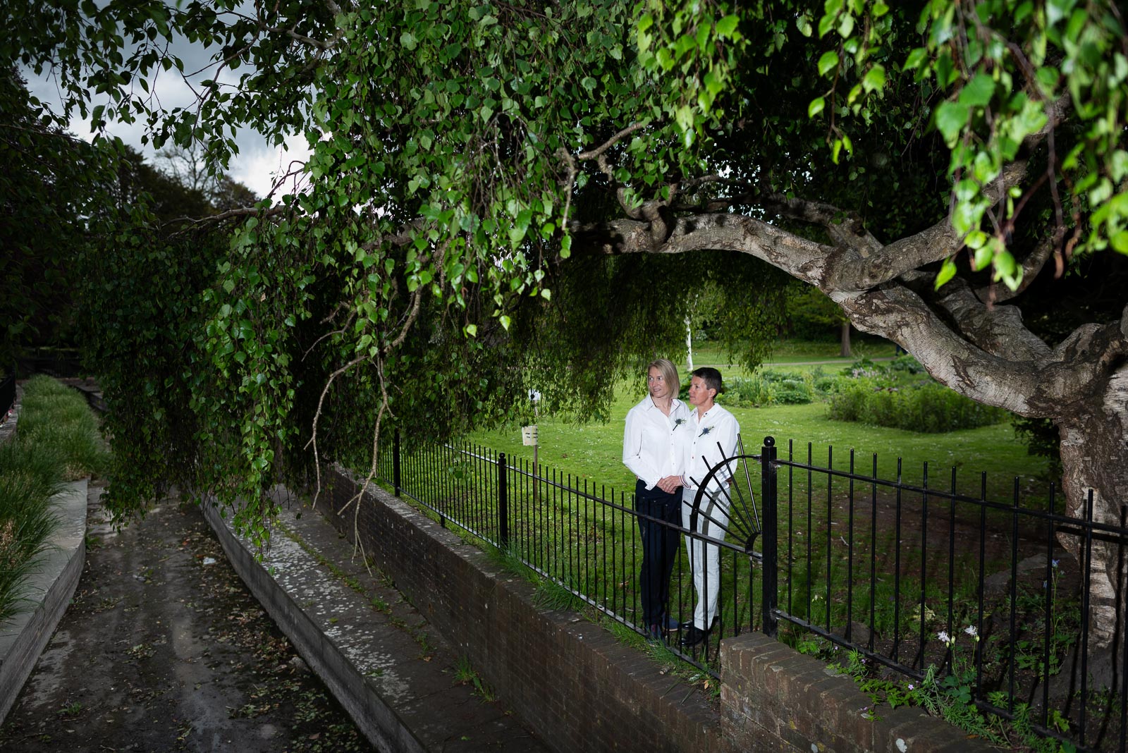 Kate and Sam pose next to the river in Southover Grange after their wedding at Lewes.