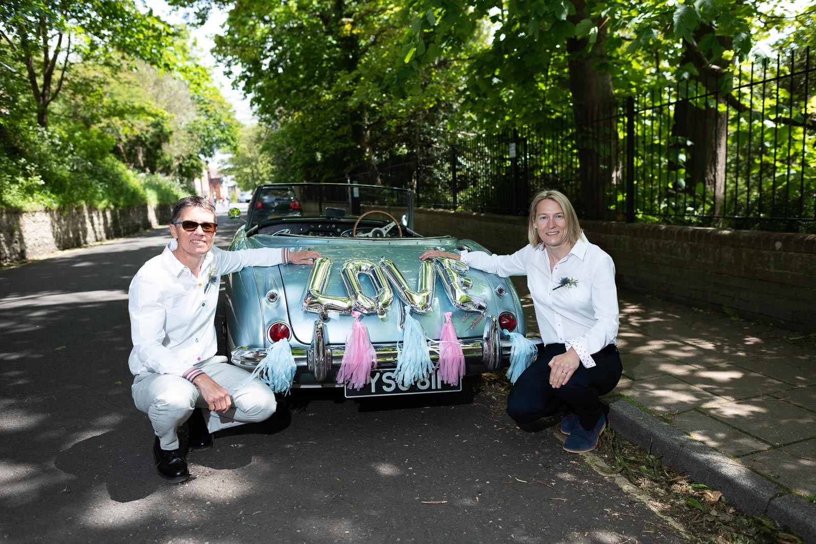 Kate and Sam pose on front of their car outside Southover Grange after their wedding at Lewes.